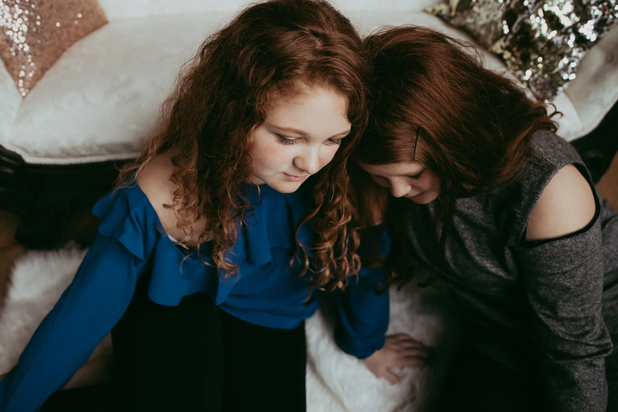red haired sisters cuddling by white couch - Minneapolis Family Photography