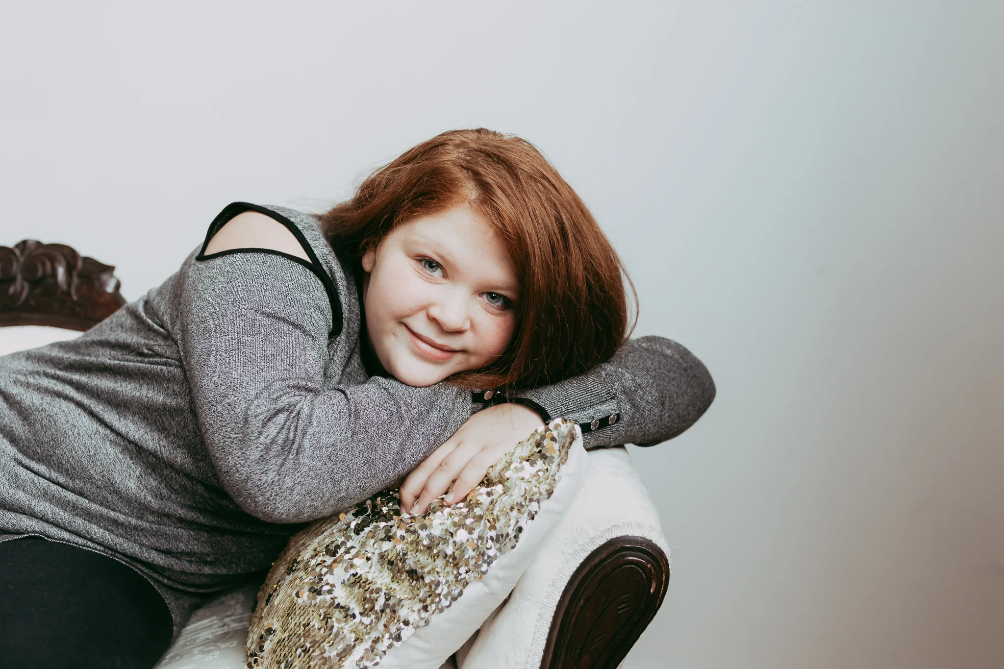 red haired girl on white couch with sequined pillow - Twin Cities Family Photographer