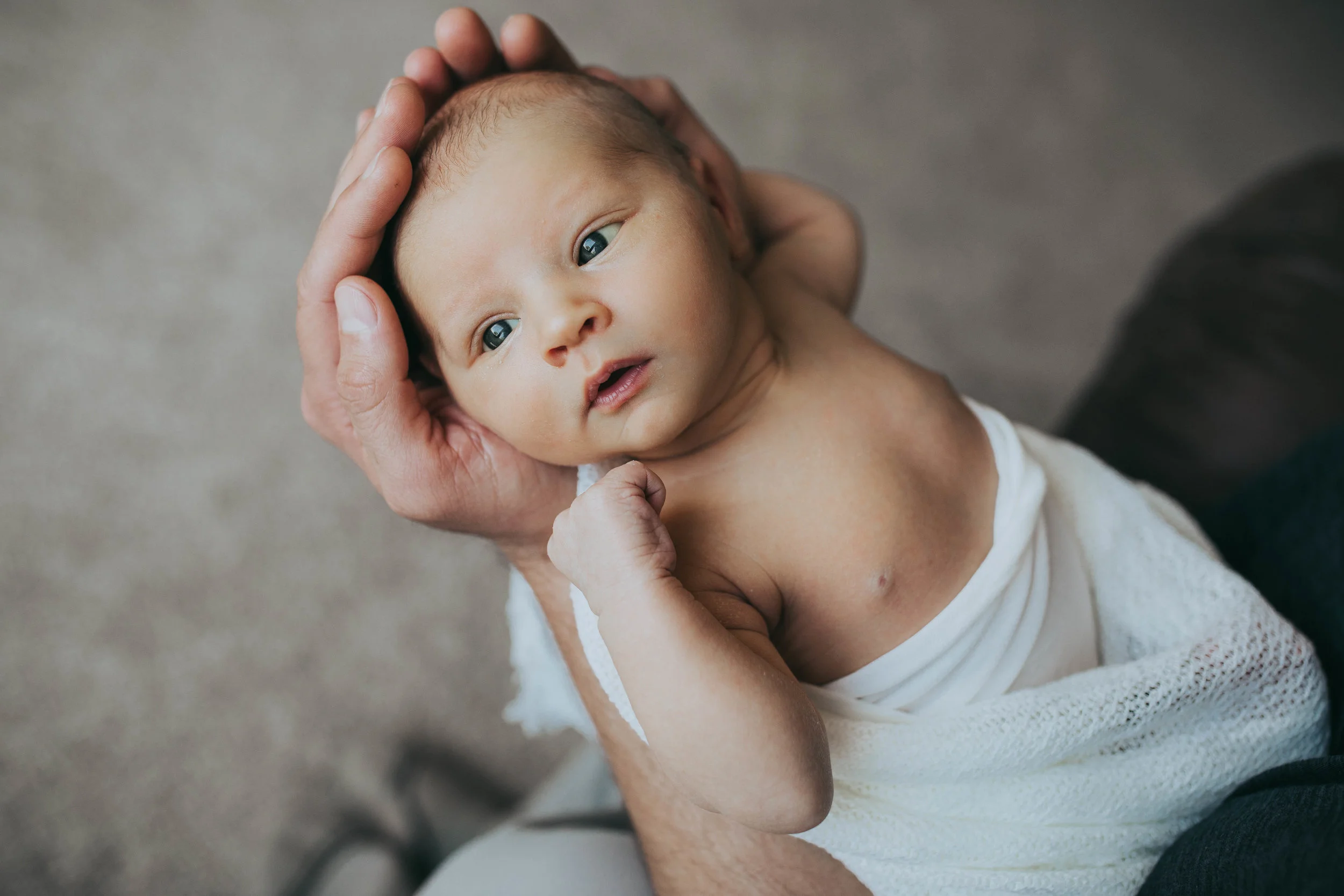 newborn baby held by father - AMG Photography