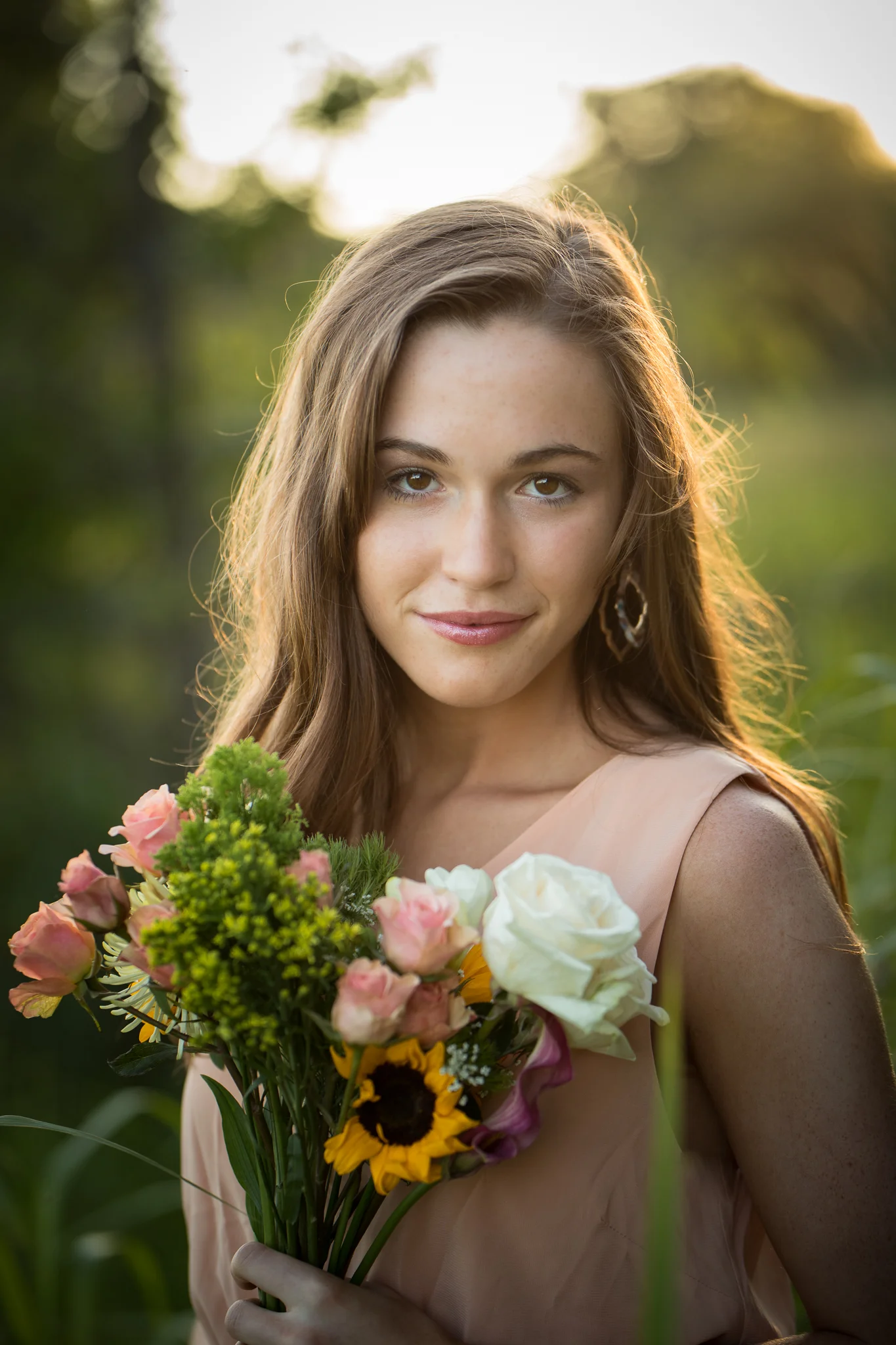 young woman in peach colored dress holding a bouquet of flowers | Minnesota Senior Photographer