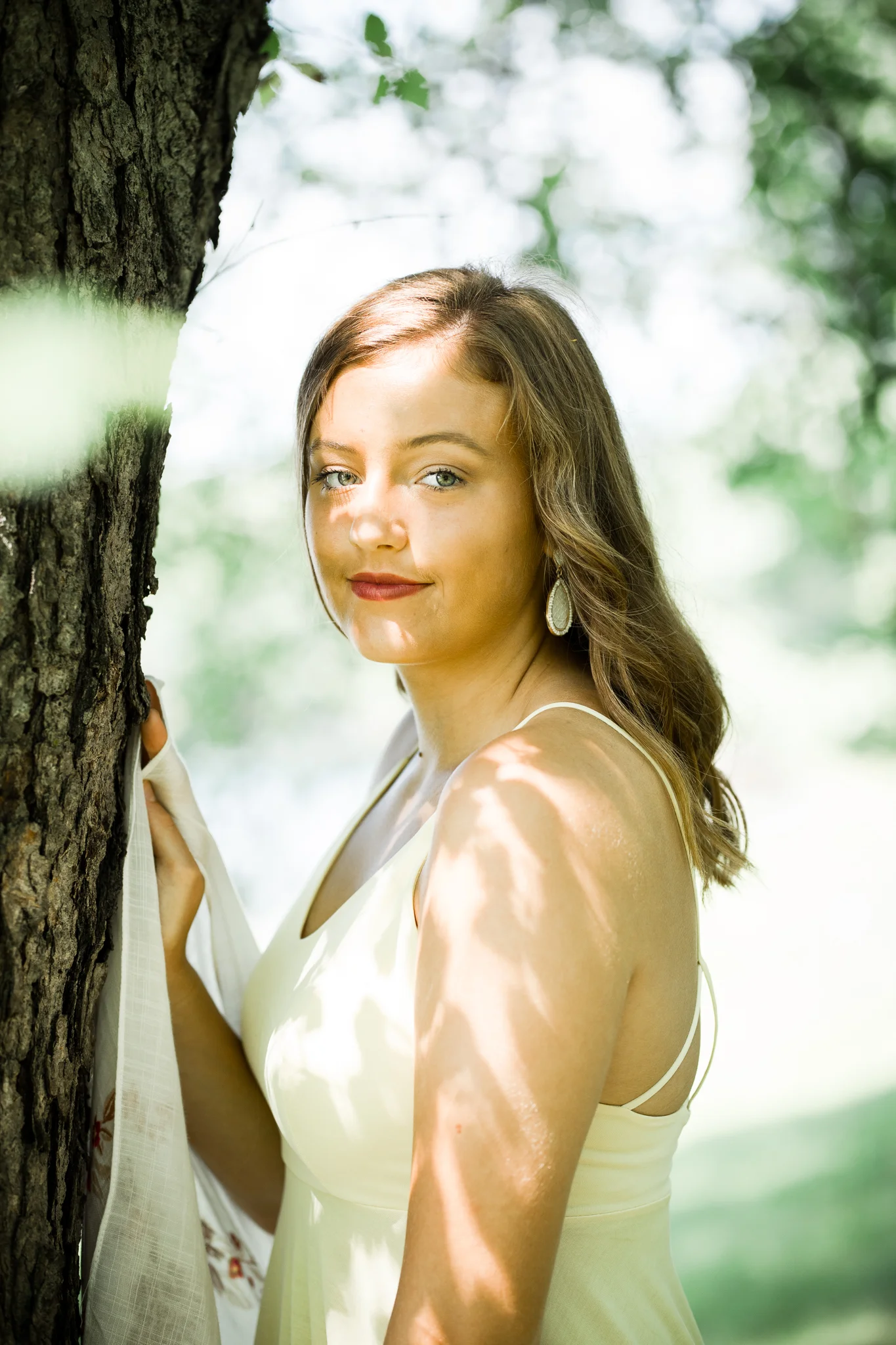 girl in yellow dress standing by a tree in the sunlight - AMG Photography