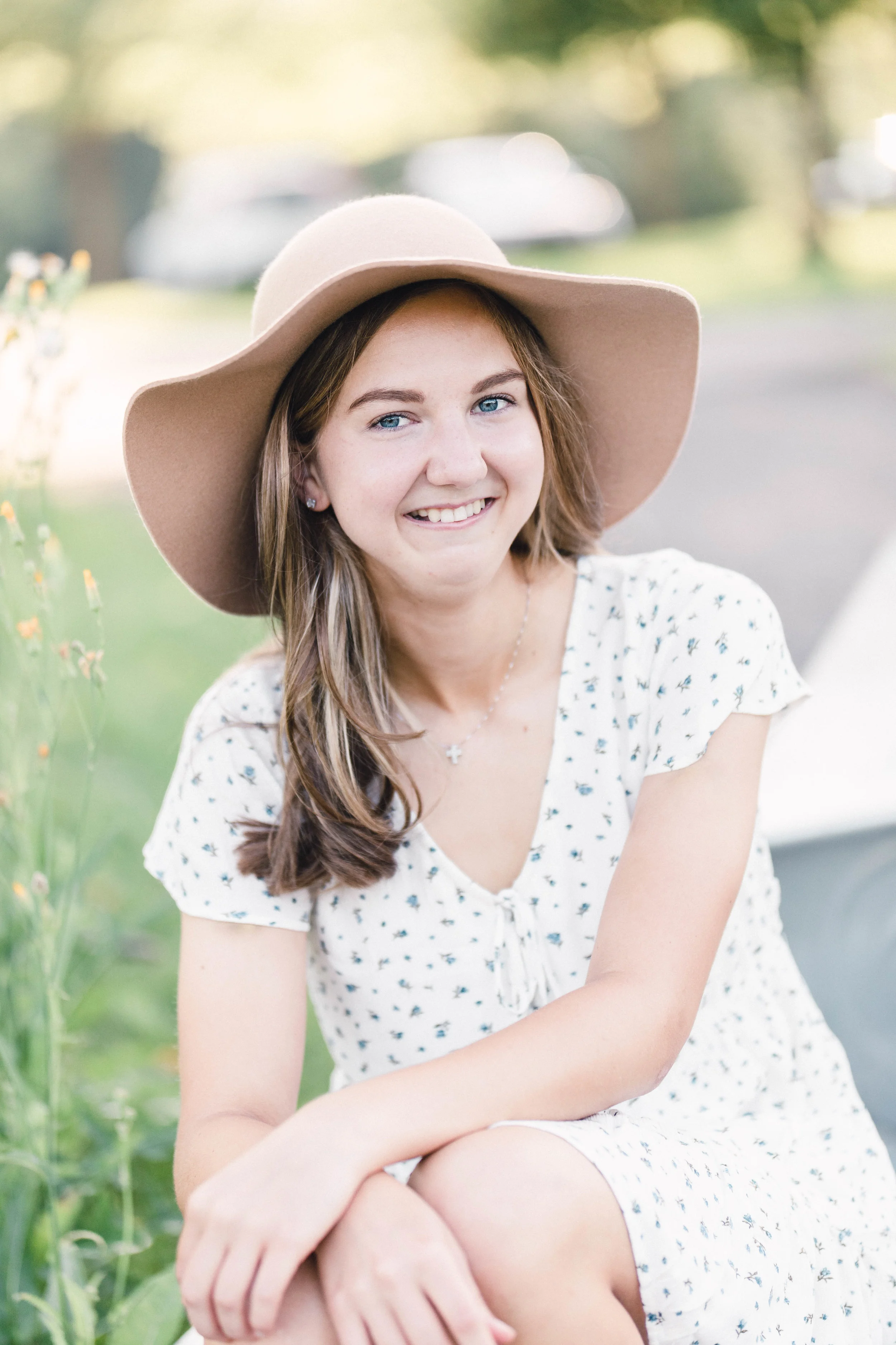 Girl sitting in a canoe by a pond wearing a hat - Minneapolis Senior Photography