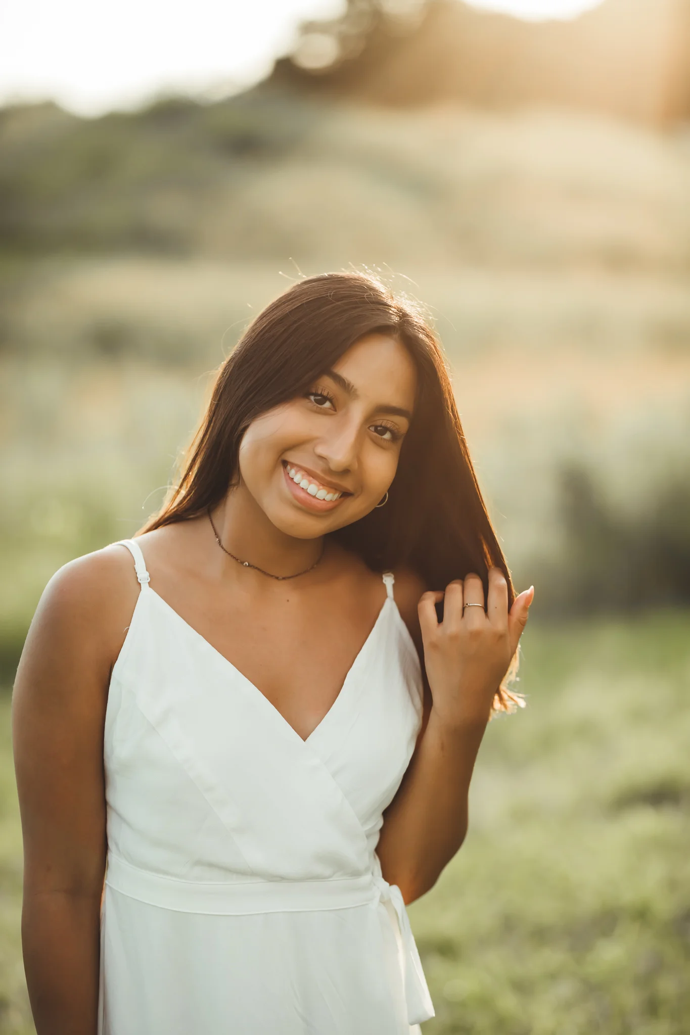 young woman in white dress posing for a photo in a field during sunset - AMG Photography