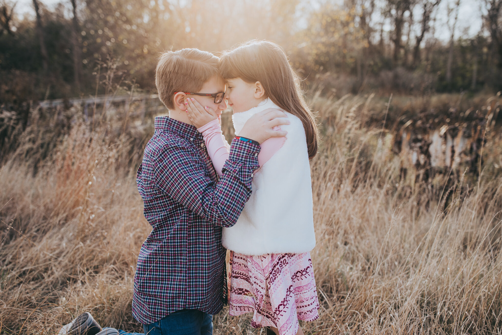 brother and sister hugging in a field at sunset | AMG Photography