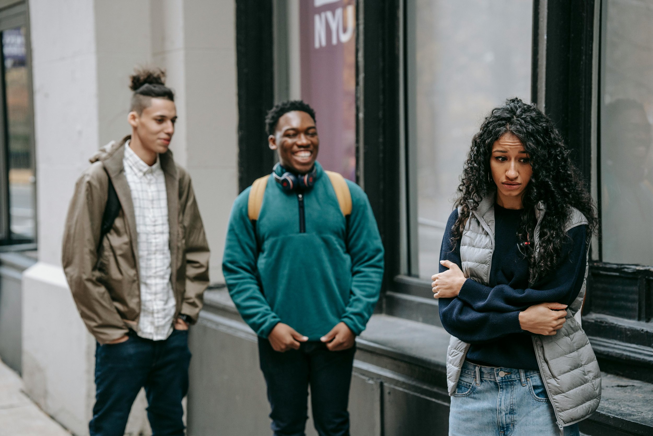 A woman with two friends laughing behind her back