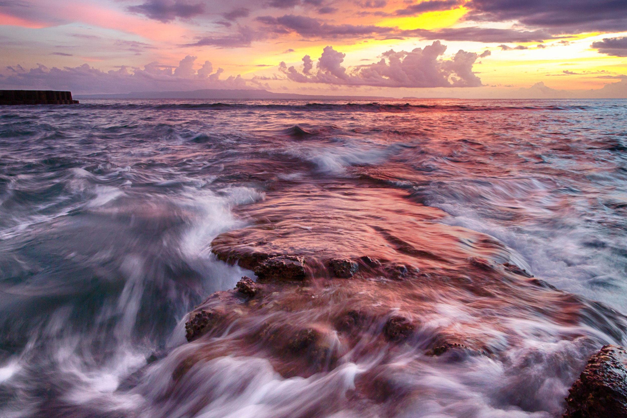 Balinese Sunset among the coastline.