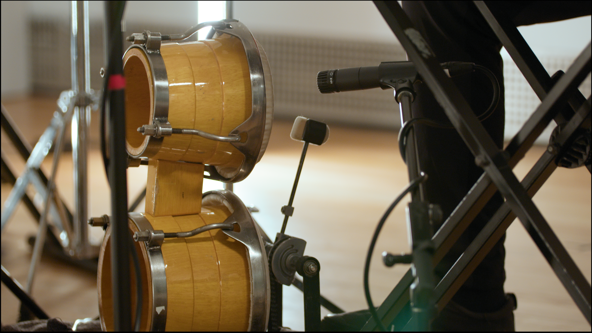 1. A close-up image of a percussionist playing a bongo with their foot.