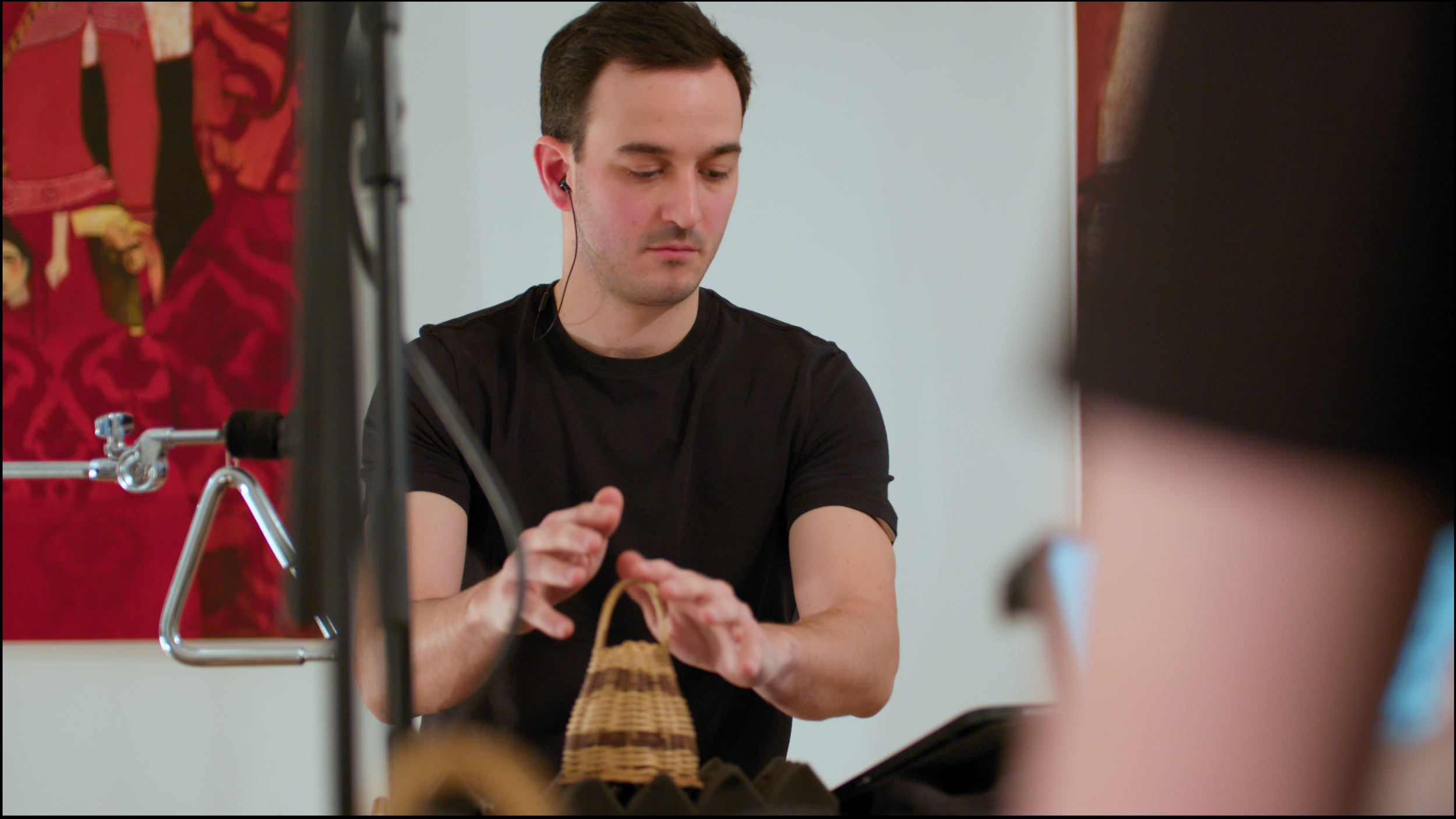 4. A close-up image of a percussionist playing a caxixi with their fingertips. The caxixi is a brown, shaker-like instrument, and is placed on a foam pad.