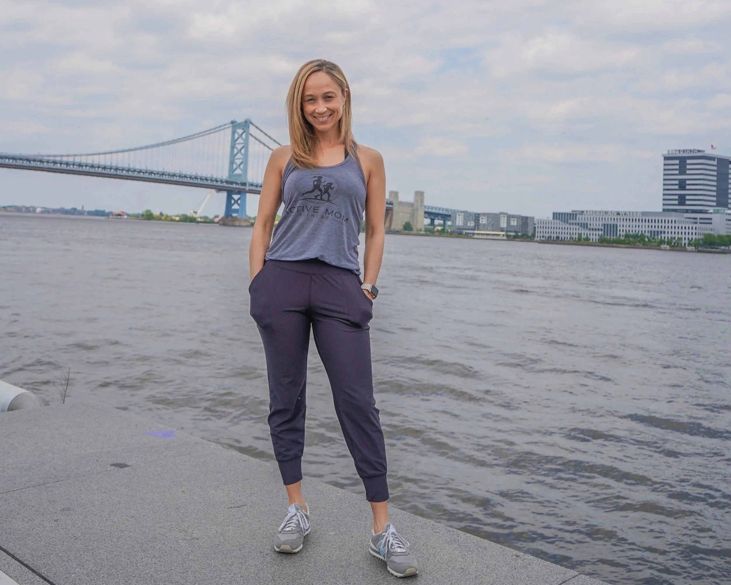 Ashley Reid standing along the river with bridge in the background