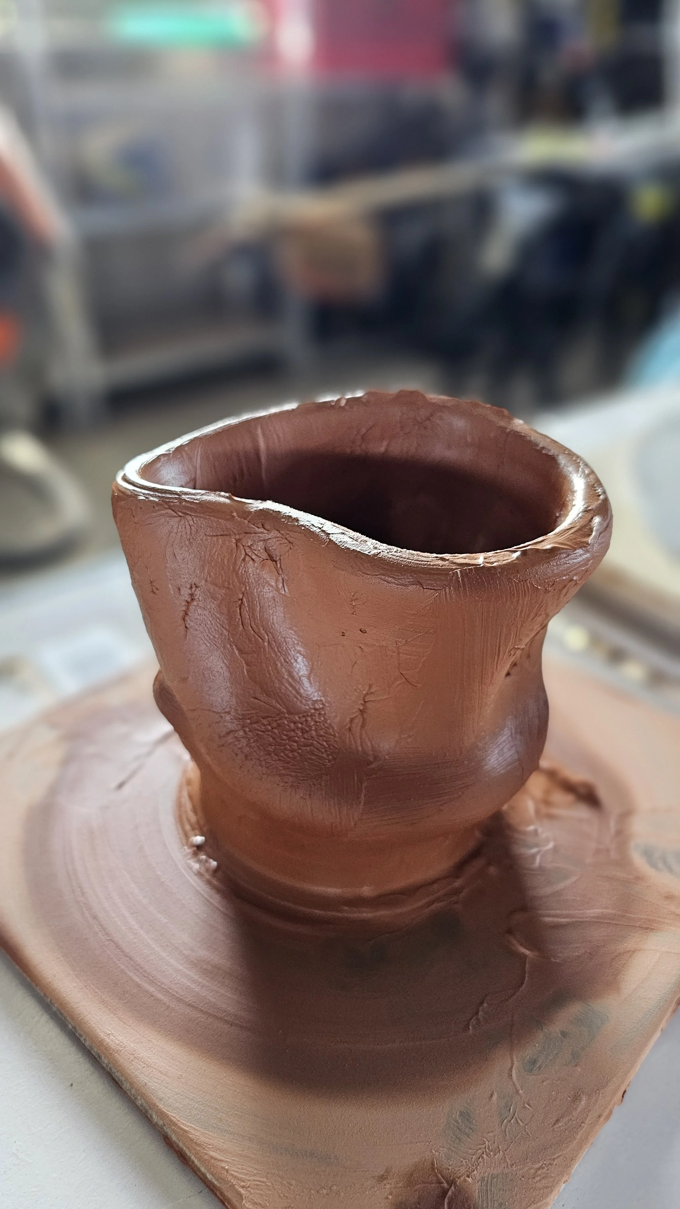 Clay-covered hands pausing to admire the form