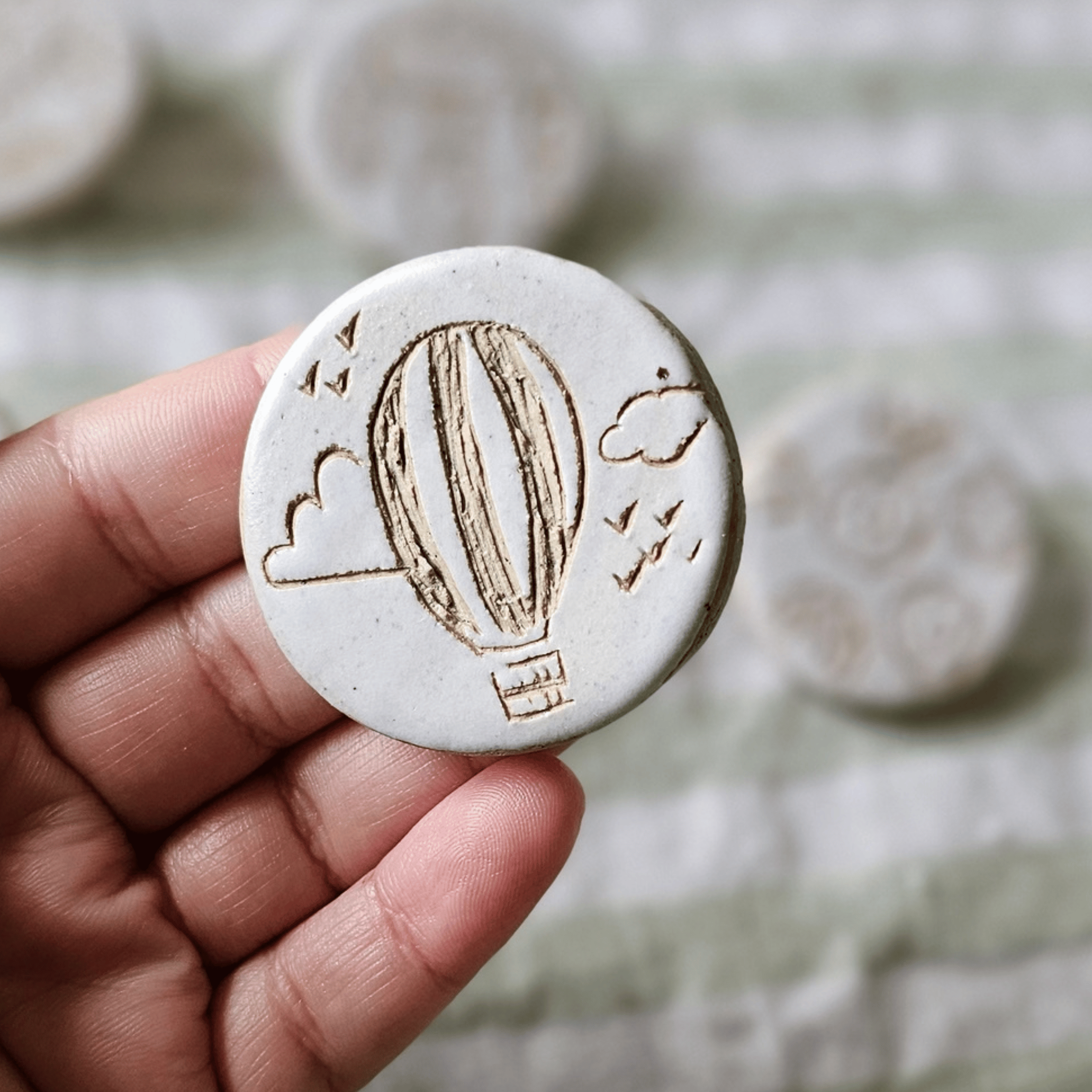 Brooch_sgraffito_white glaze_in hand_balloons.png