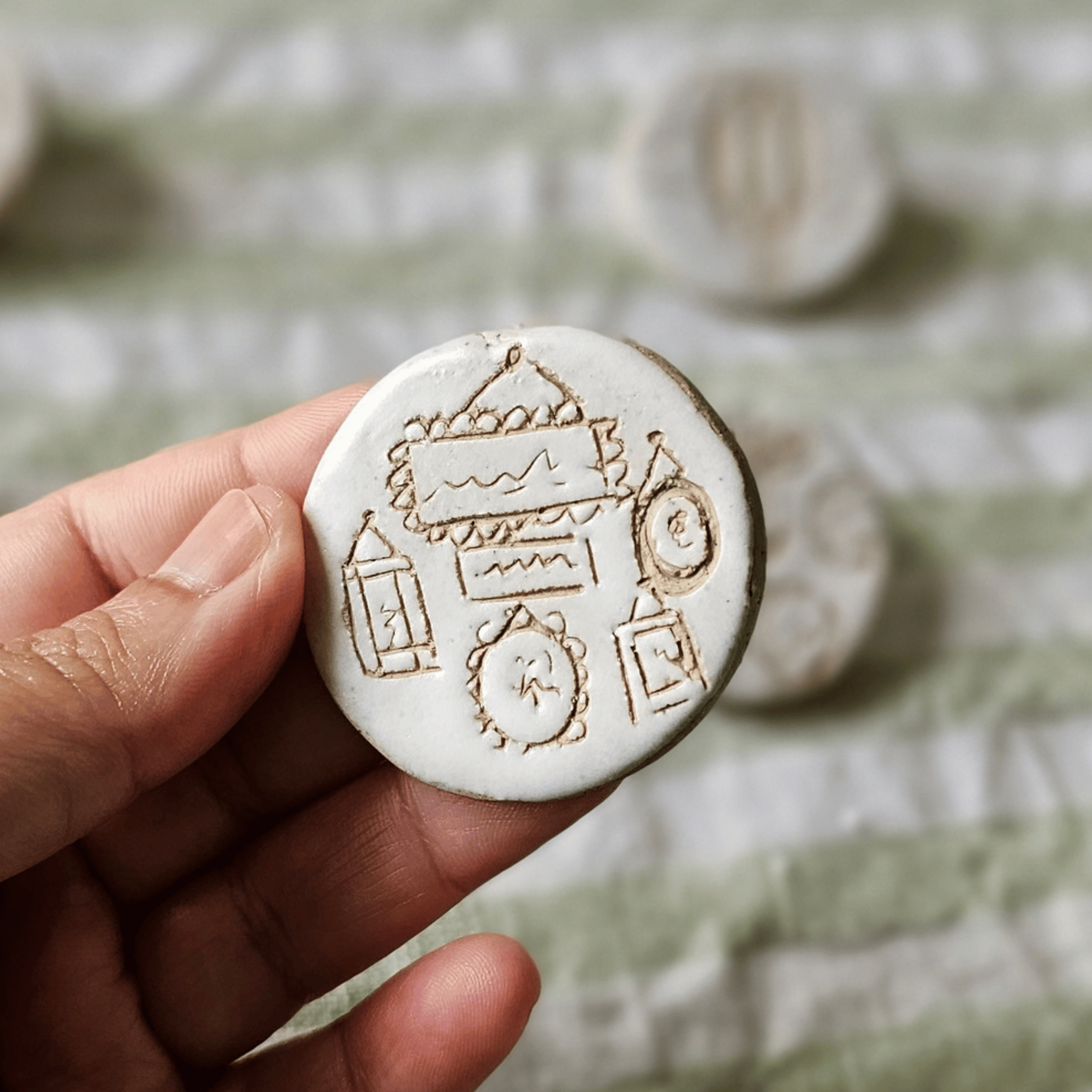 Brooch_sgraffito_white glaze_in hand_frames.png