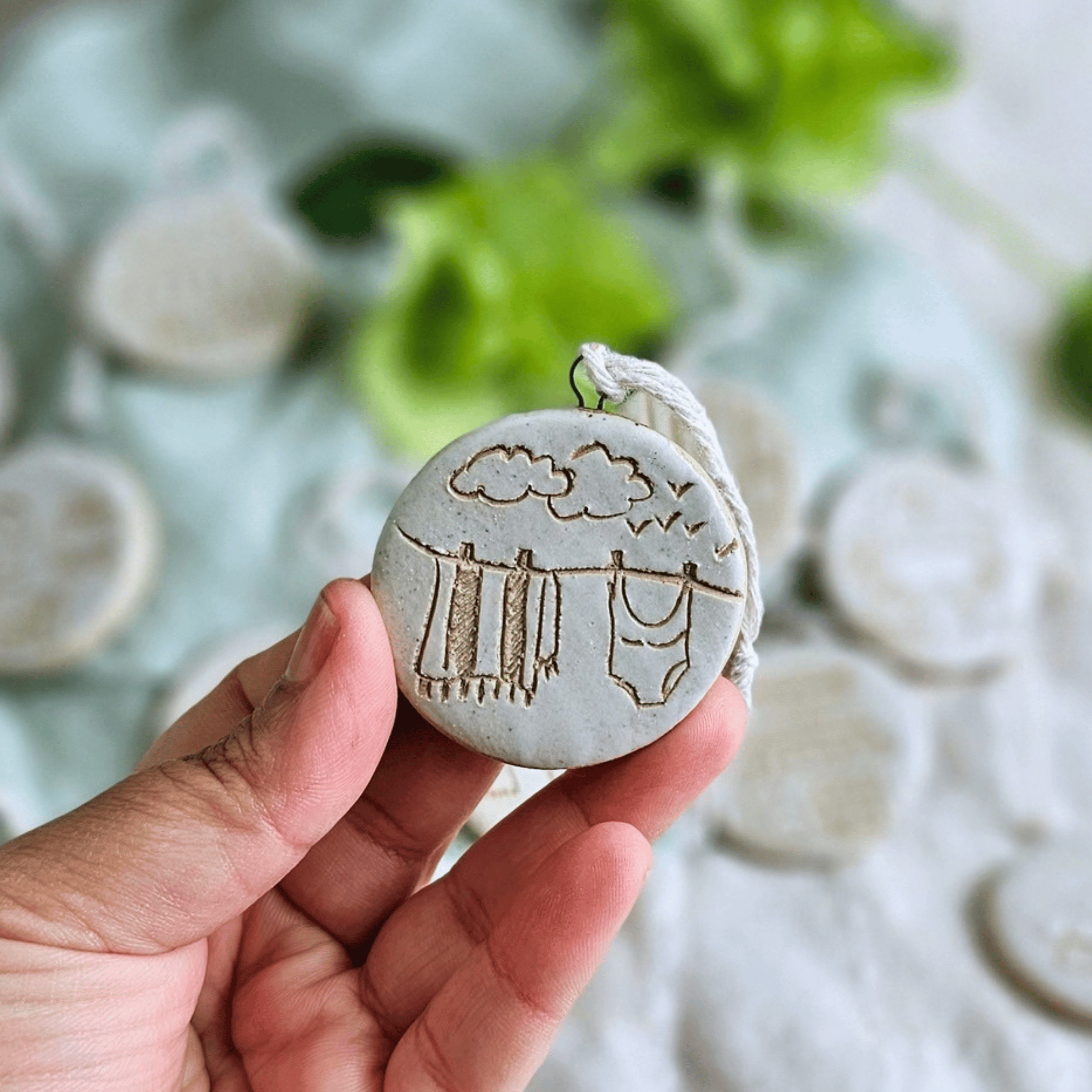 Ornaments_sgraffito_white glaze_in hand_towel swimmers on the line.png