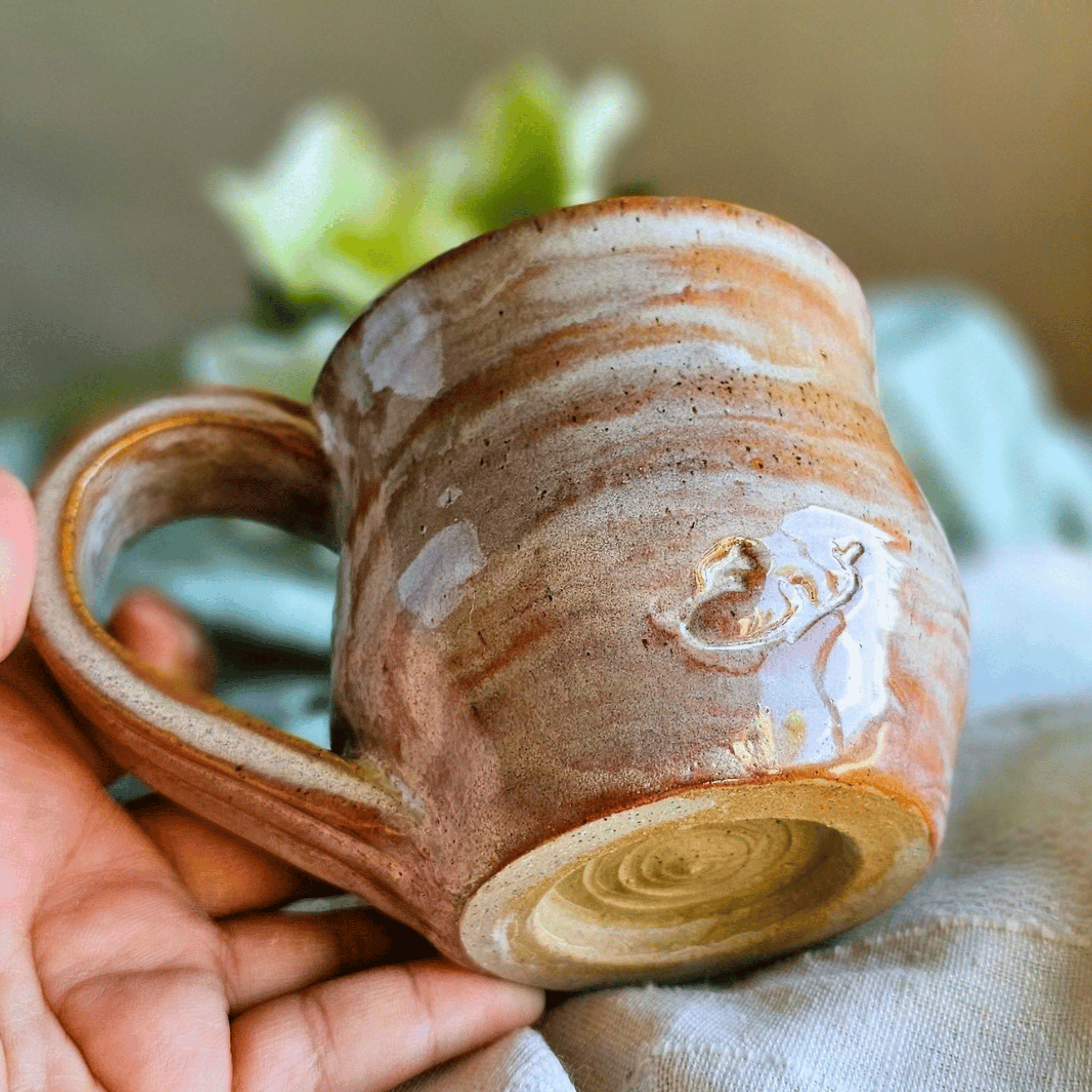 Smug Mug_handled_hand carved_female lead_in hand_bottom.png