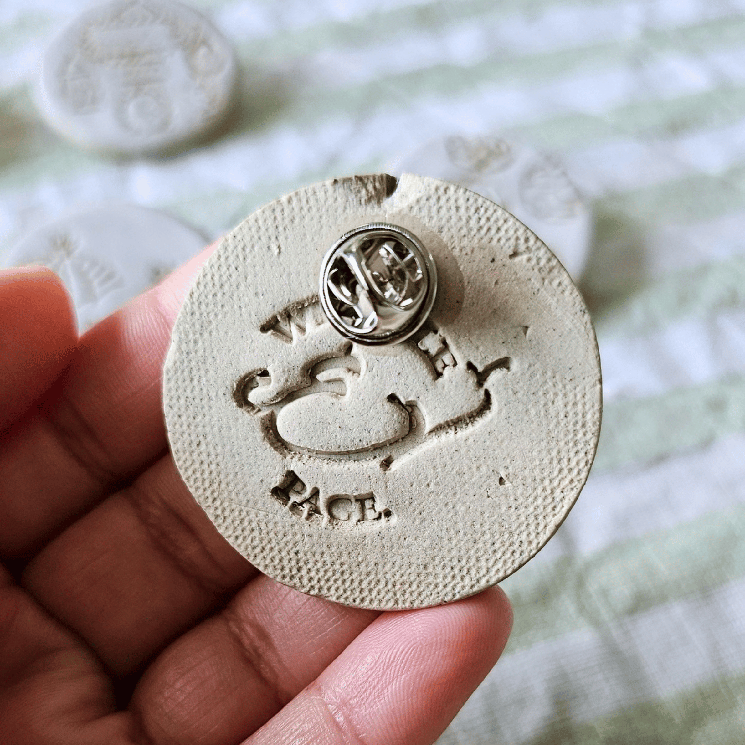 Brooch_sgraffito_white glaze_in hand_back.png