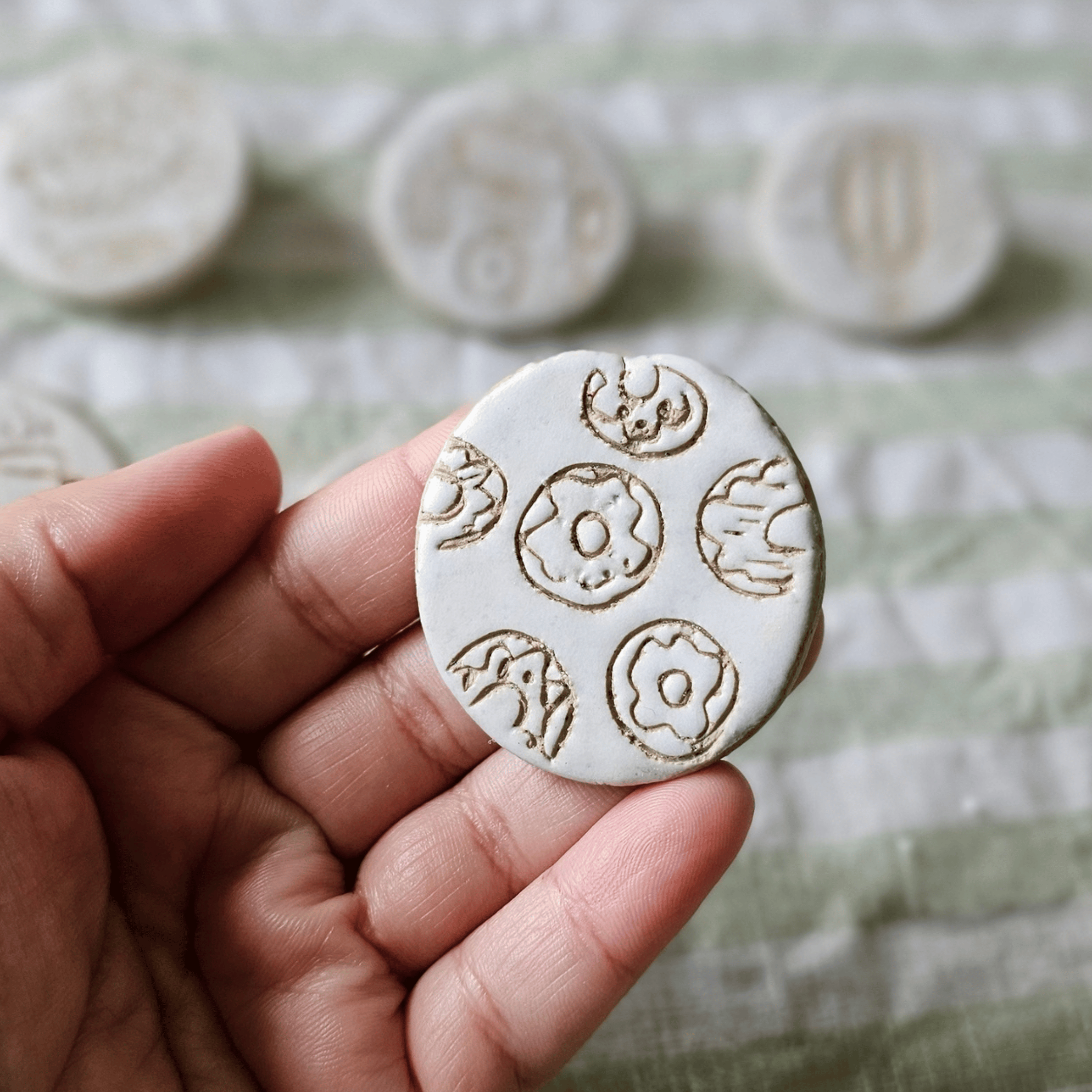 Brooch_sgraffito_white glaze_in hand_doughnuts.png