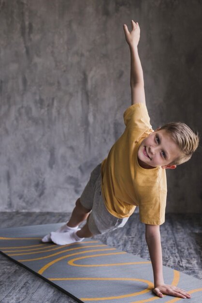 fitness-boy-exercising-exercise-mat-front-concrete-wall_23-2148186377.jpeg