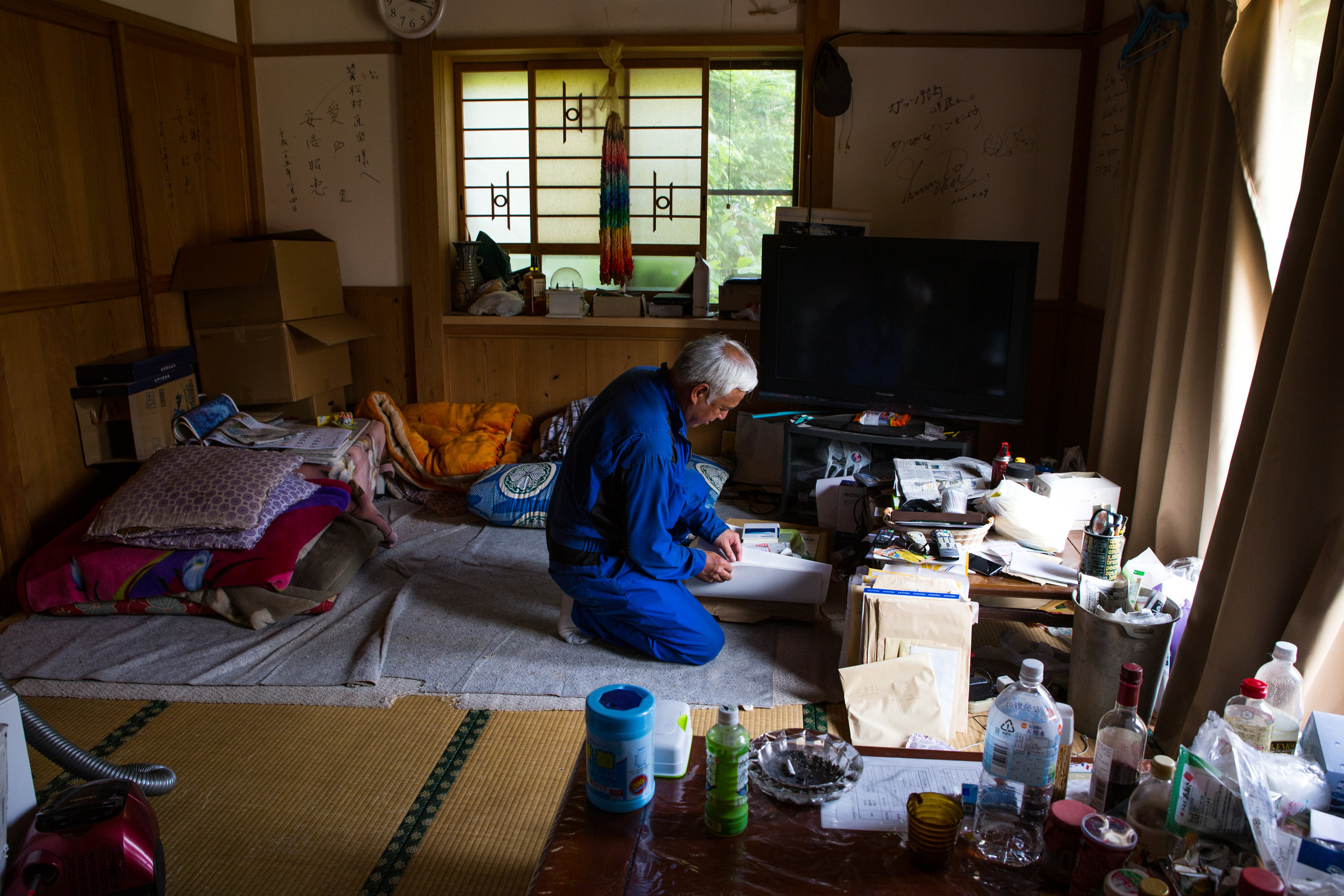  Matsumura wears a bright blue jumpsuit and smokes 30 cigarettes a day. His house is filled with bottles of whiskey and beer, packaged food, piles of paper and a collection of cranes from an anti-nuclear rally in France. 