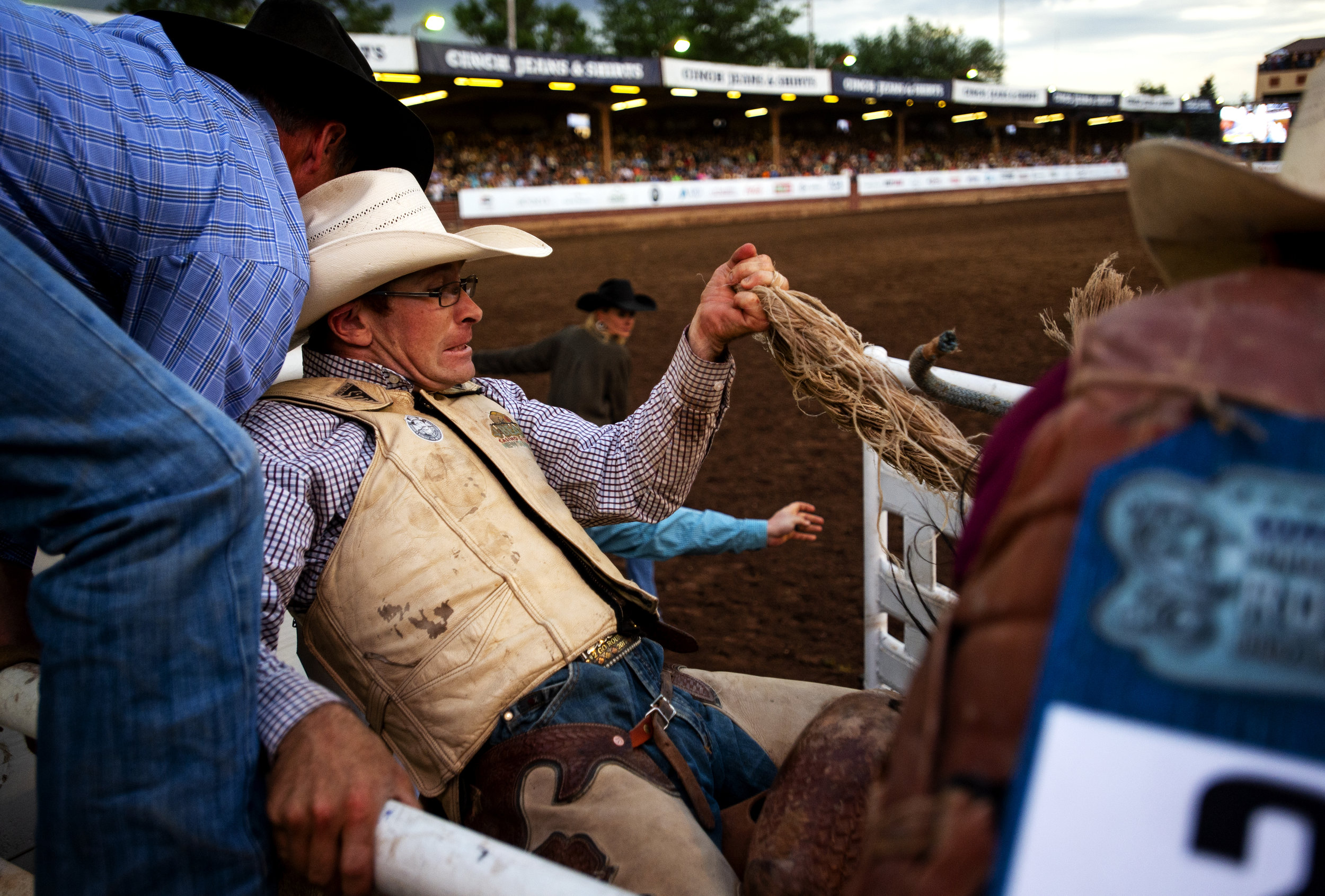  Dusty Hausauer, of Dickinson, N.D., holds on to the railing and his bronc rain as he gets ready to leave the chutes during the saddle bronc competition, at the 79th annual Pikes Peak or Bust Rodeo at the Norris-Penrose Event Center  in Colorado Spri