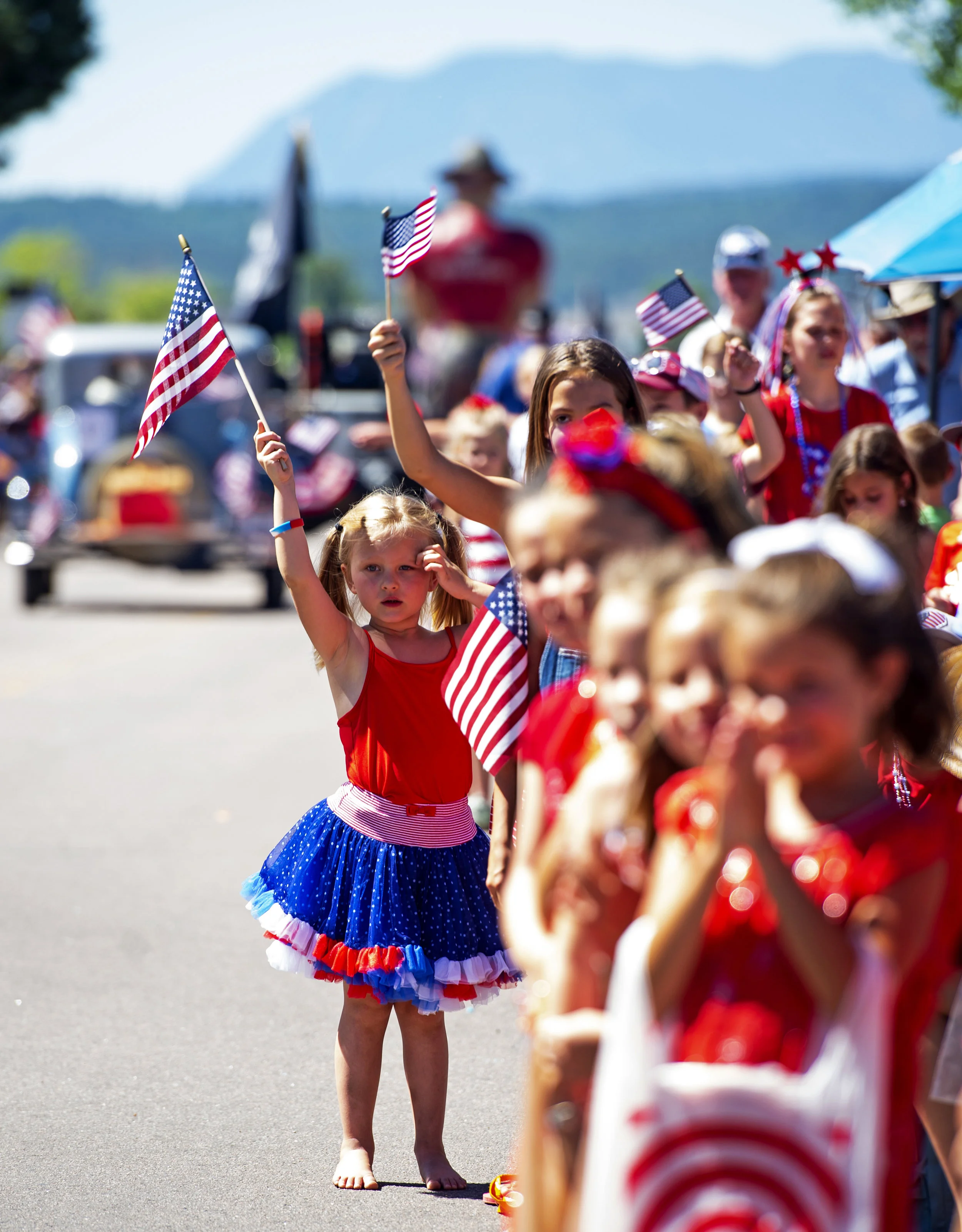  Hannah Chmelik, 5, steps out from a group of kids to wave her flag at a passing float in the Monument Hill Kiwanis 4th of July Parade in Monument on Thursday, July 4, 2019.  