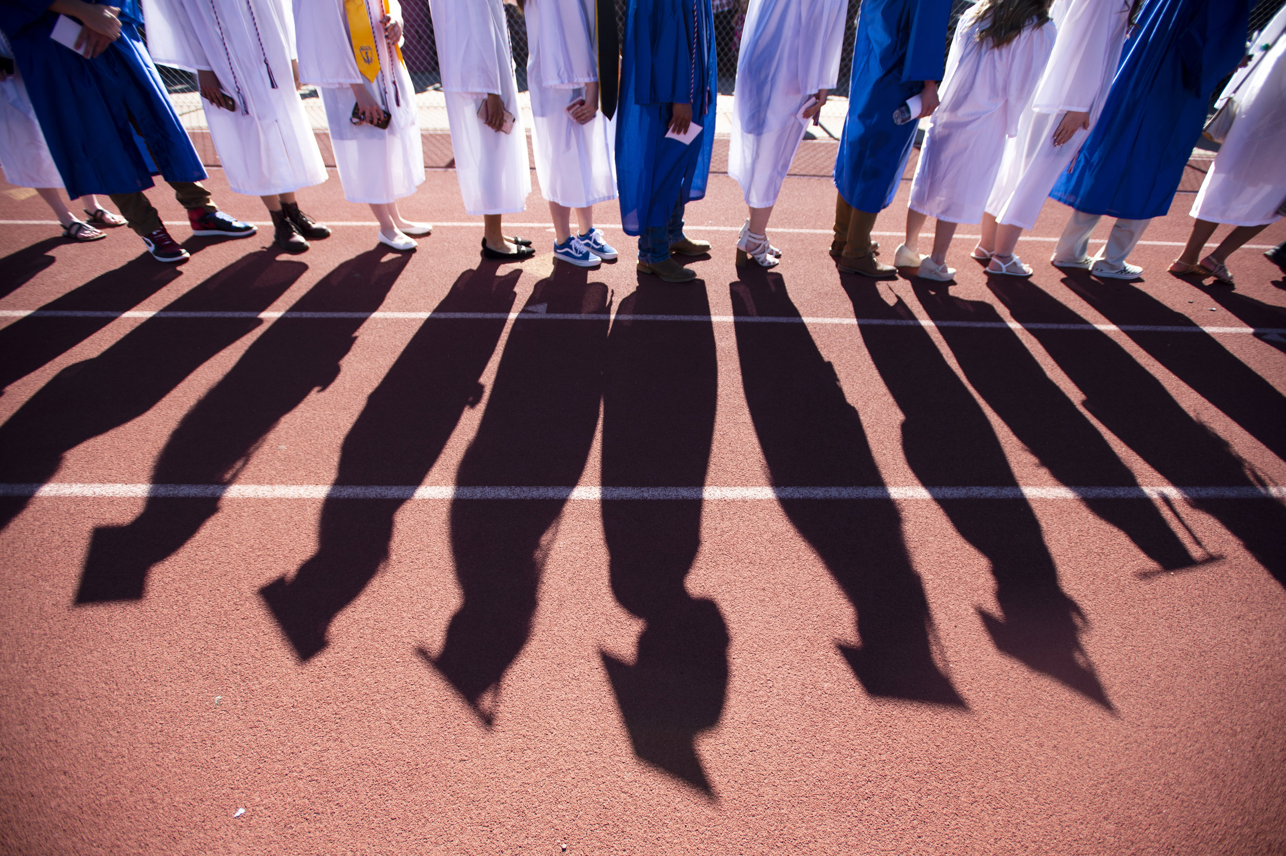  Graduates cast shadows on the track at the Fountain Fort Caron High School class of 2019 graduation in Fountain, Colo., on Saturday, May 25, 2019. 