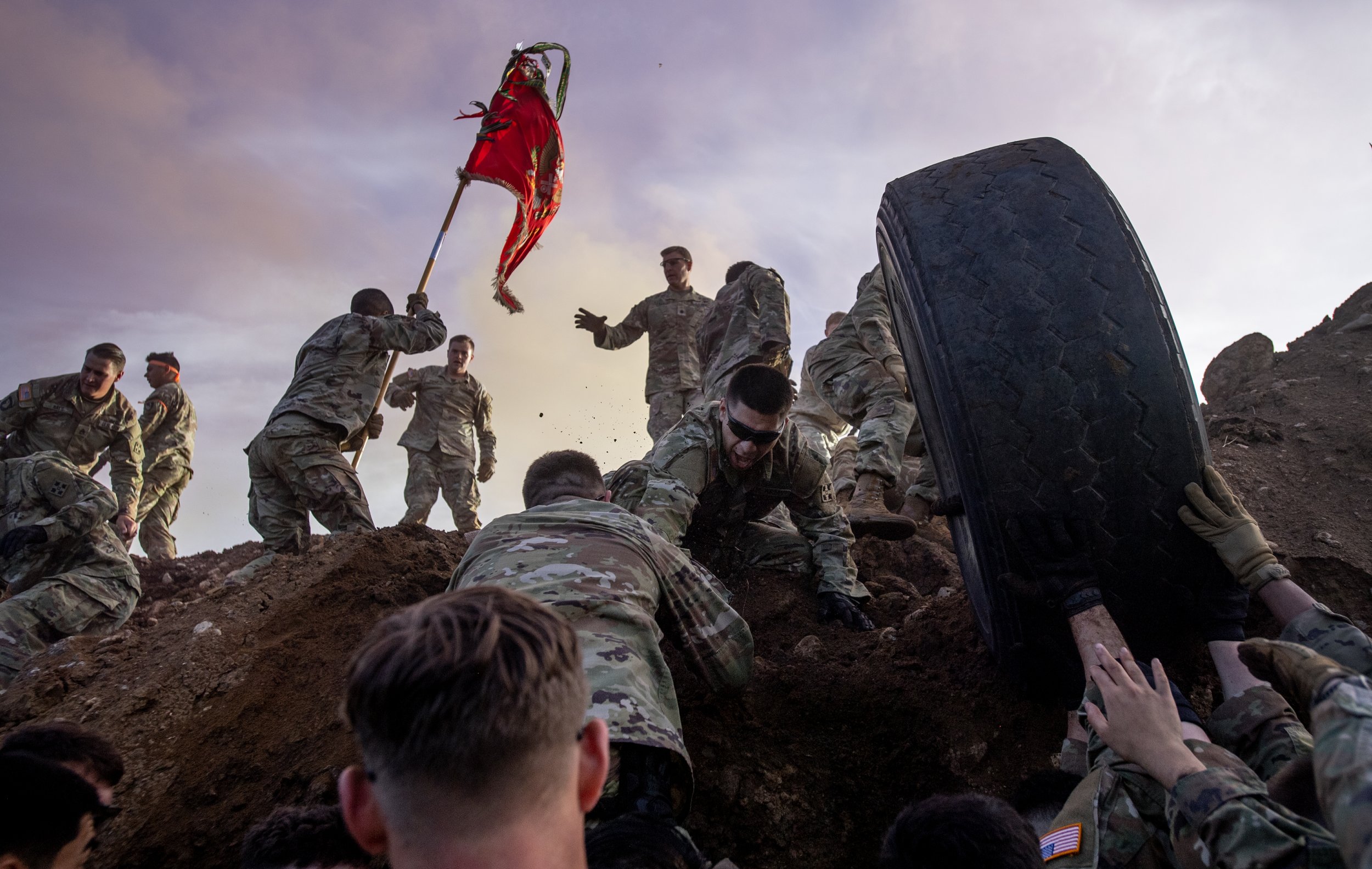  Fort Carson soldiers scale their way out of and push a tire out of an anti-tank ditch during the the Battle of Kamdesh physical training exercise on base on Friday, June 9 , 2023.  The exercise honored the eight fallen 4th Infantry Division soldiers