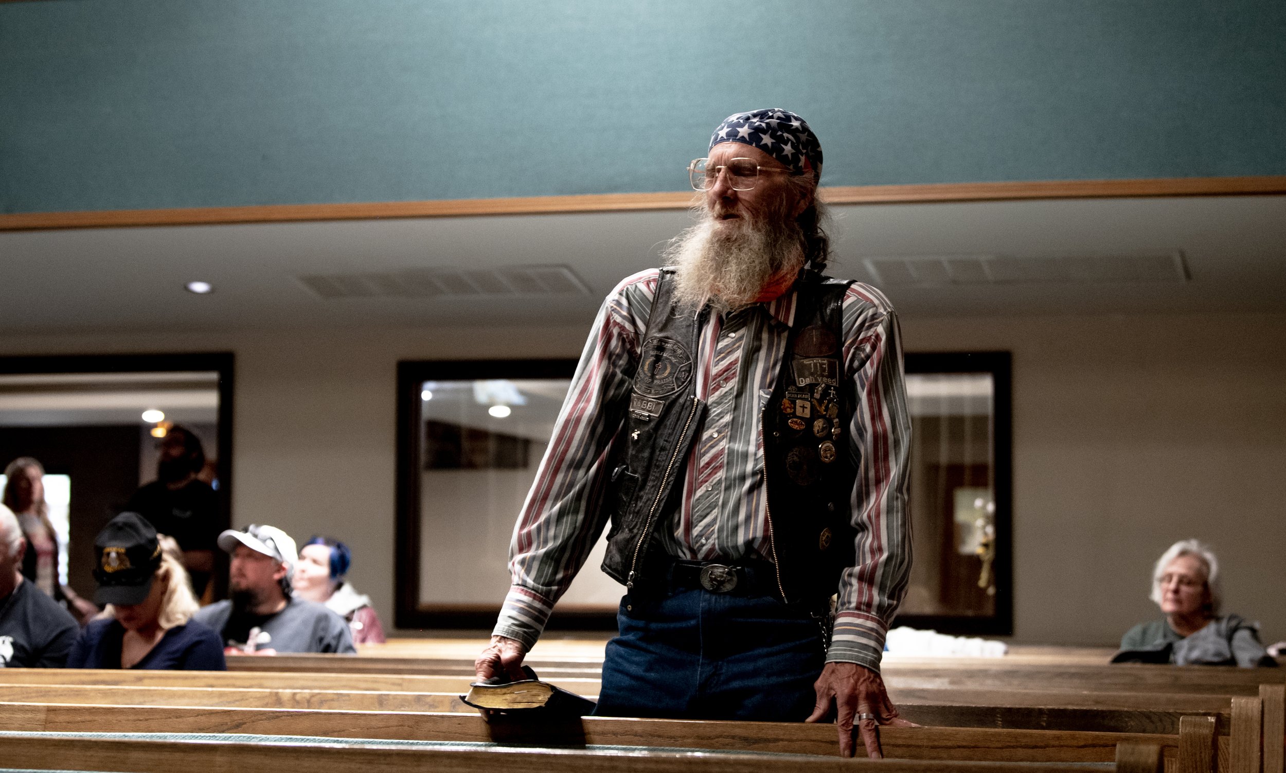  David Bordeau stands as he sings a hymn during a Biker’s Church service on Saturday, March 25, 2023 in Colorado Springs, Colo. Bordeau says after decades of being an atheist, struggling with homelessness and being in and our of jail, he found God an