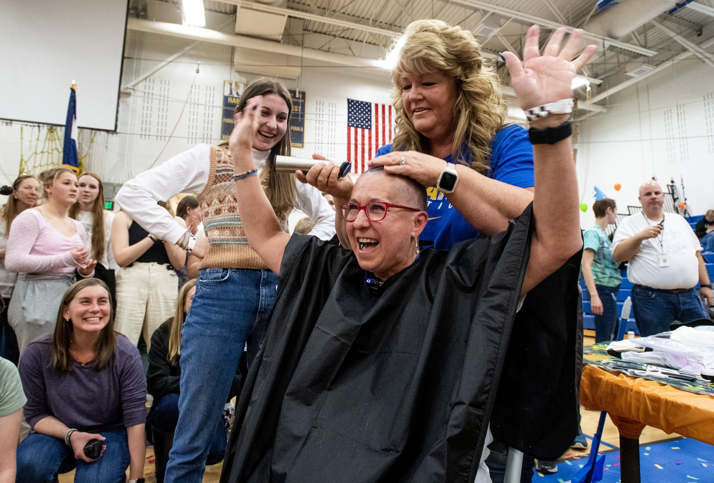  Tana Tornquist smiles as her head is shaved Friday, March 10, 2023, during the 16th Annual Bald For Bucks fundraiser at Rampart High School in Colorado Springs, Colo. Dozens of students, staff and community members shaved their heads or cut off thei