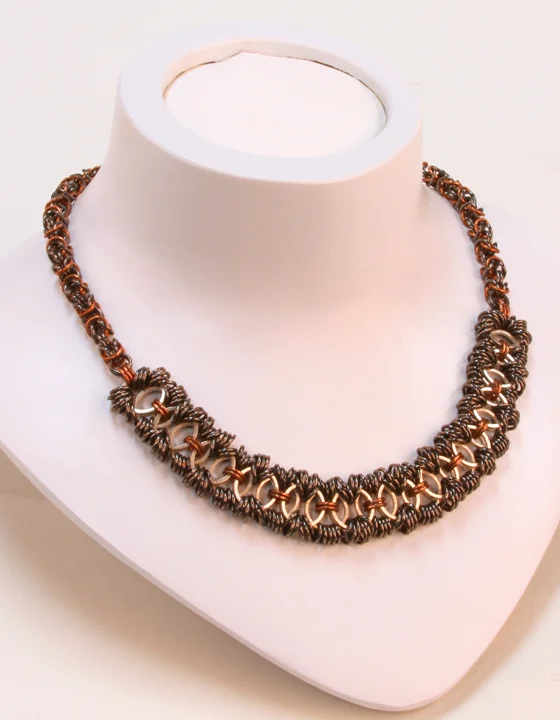  This piece is copper-, silver-, and black-colored copper chainmaille in traditional byzantine and Celtic-variation pattern. It's a one-of-a-kind, 18 inch piece with a toggle closure.  Available at:  https://www.etsy.com/listing/105115269/laura-colle