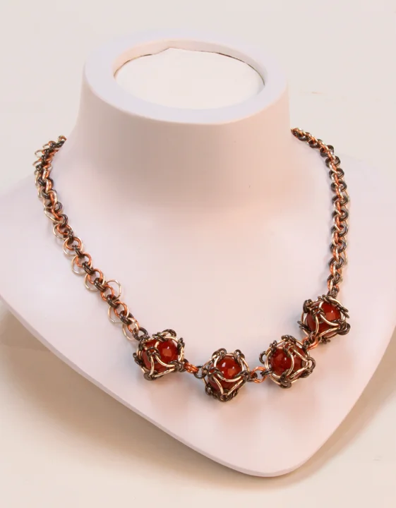  This piece is copper-, silver-, and black-colored copper chainmaille with chainmaille wrapped fire again. It's a one-of-a-kind piece with a toggle closure. 