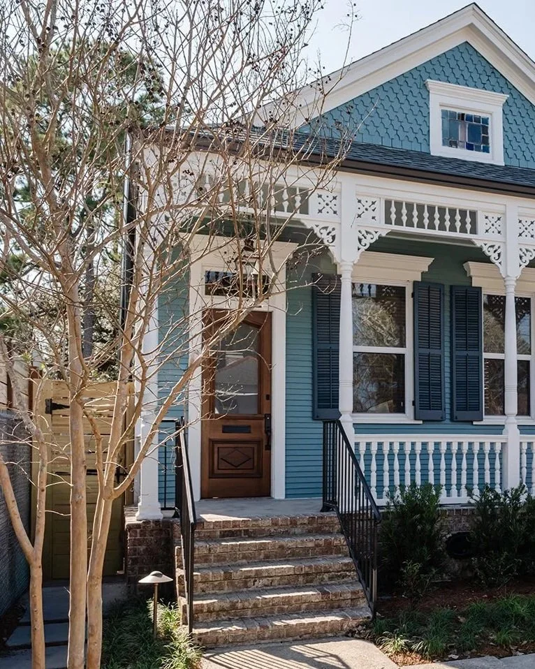 Exterior: Restored blue double shotgun exterior with original fretwork and shutters in Riverbend, New Orleans