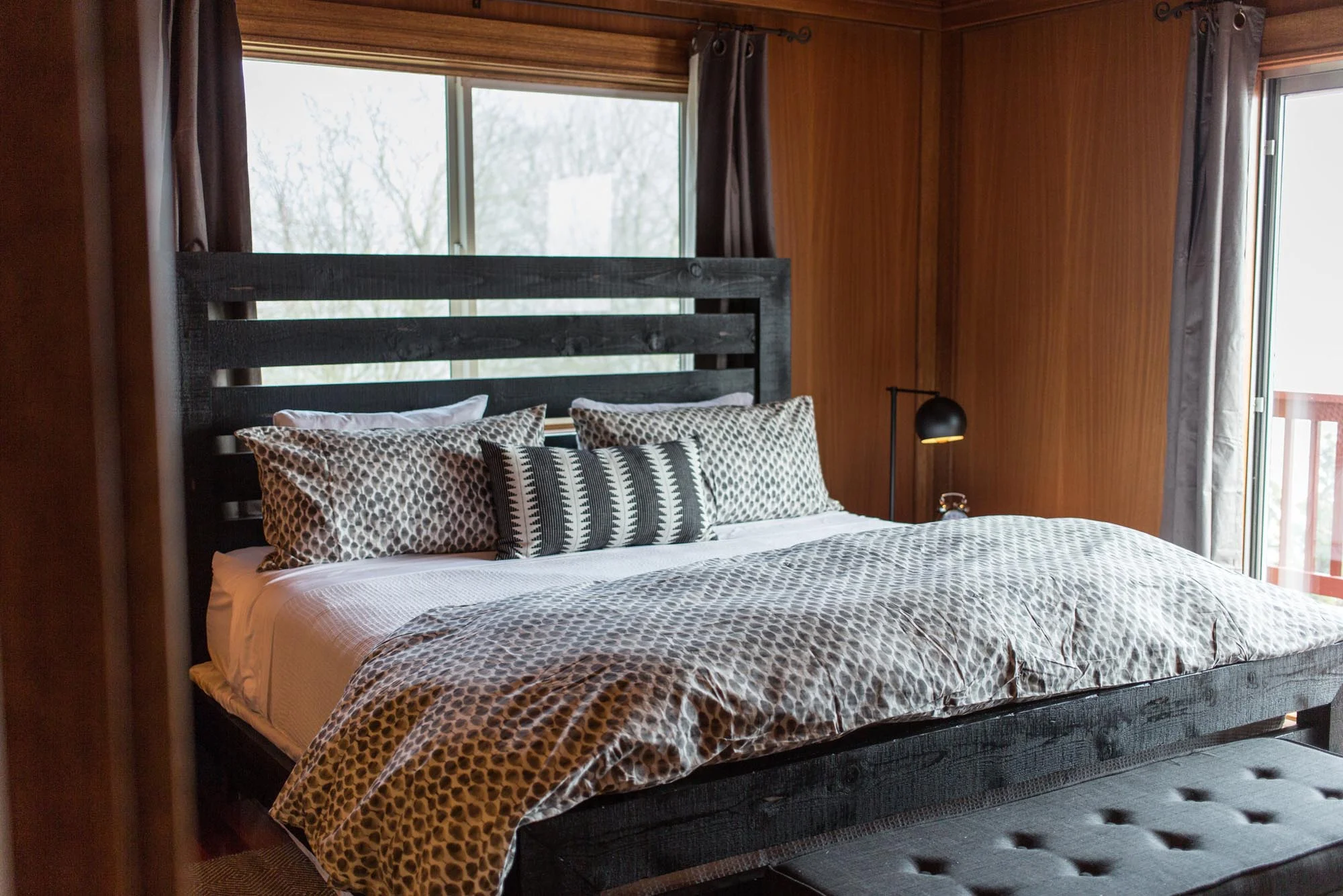 King bed with graphic bedding and wood paneling
