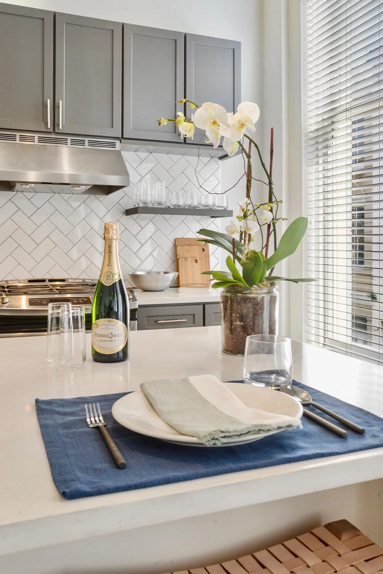 White kitchen island with place setting and flowers