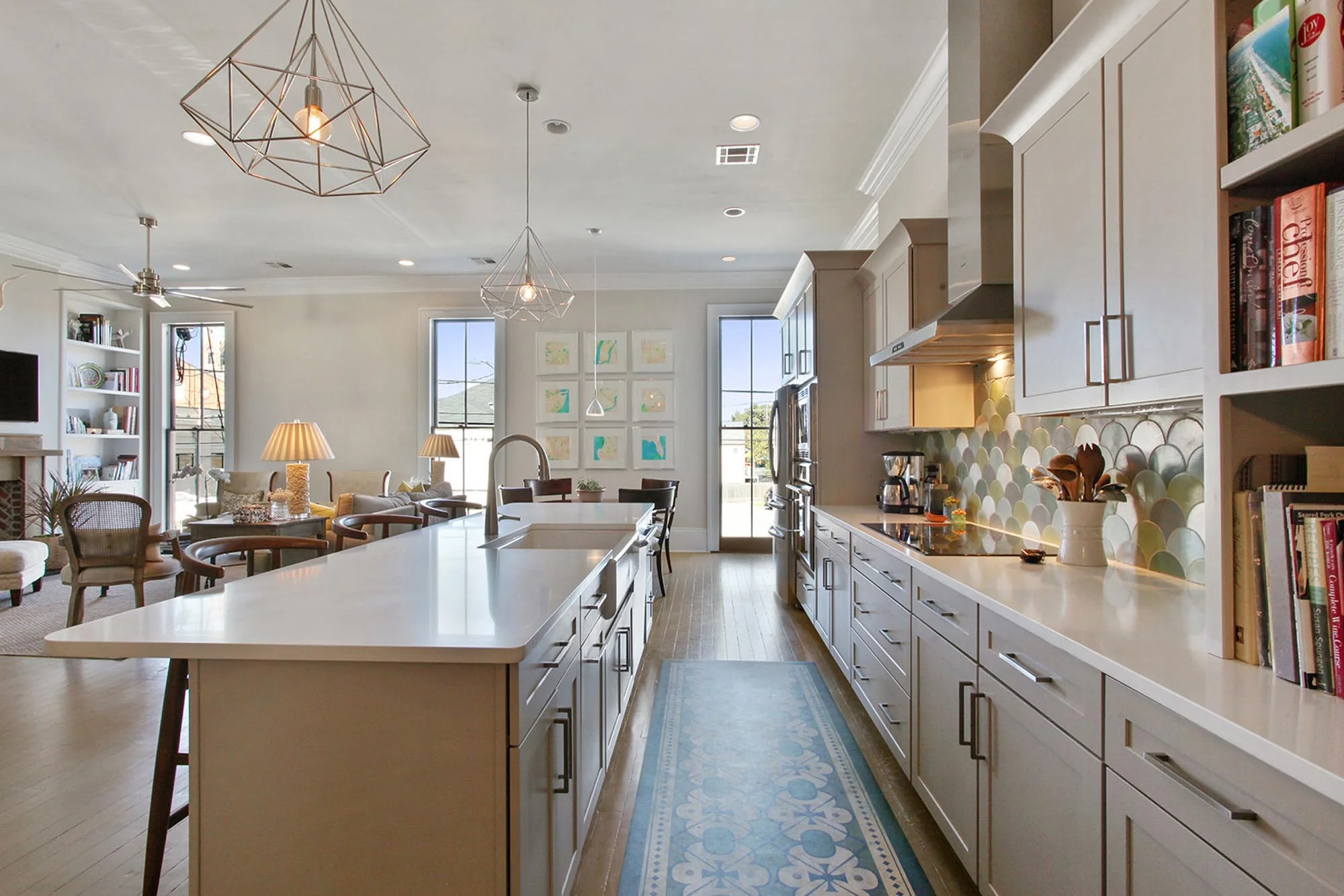 Long kitchen island with geometric hanging metal light fixture above