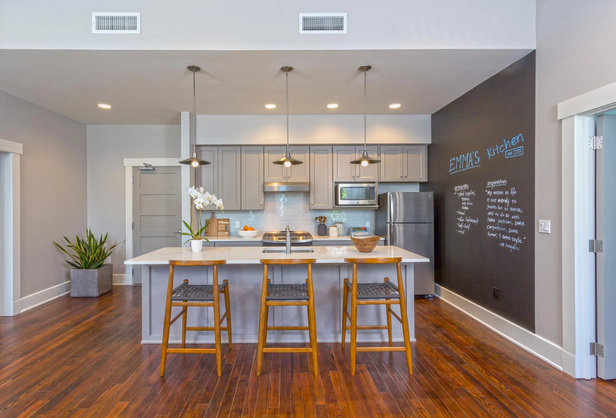 Kitchen area painted white and grey, with one wall covered with a blackboard