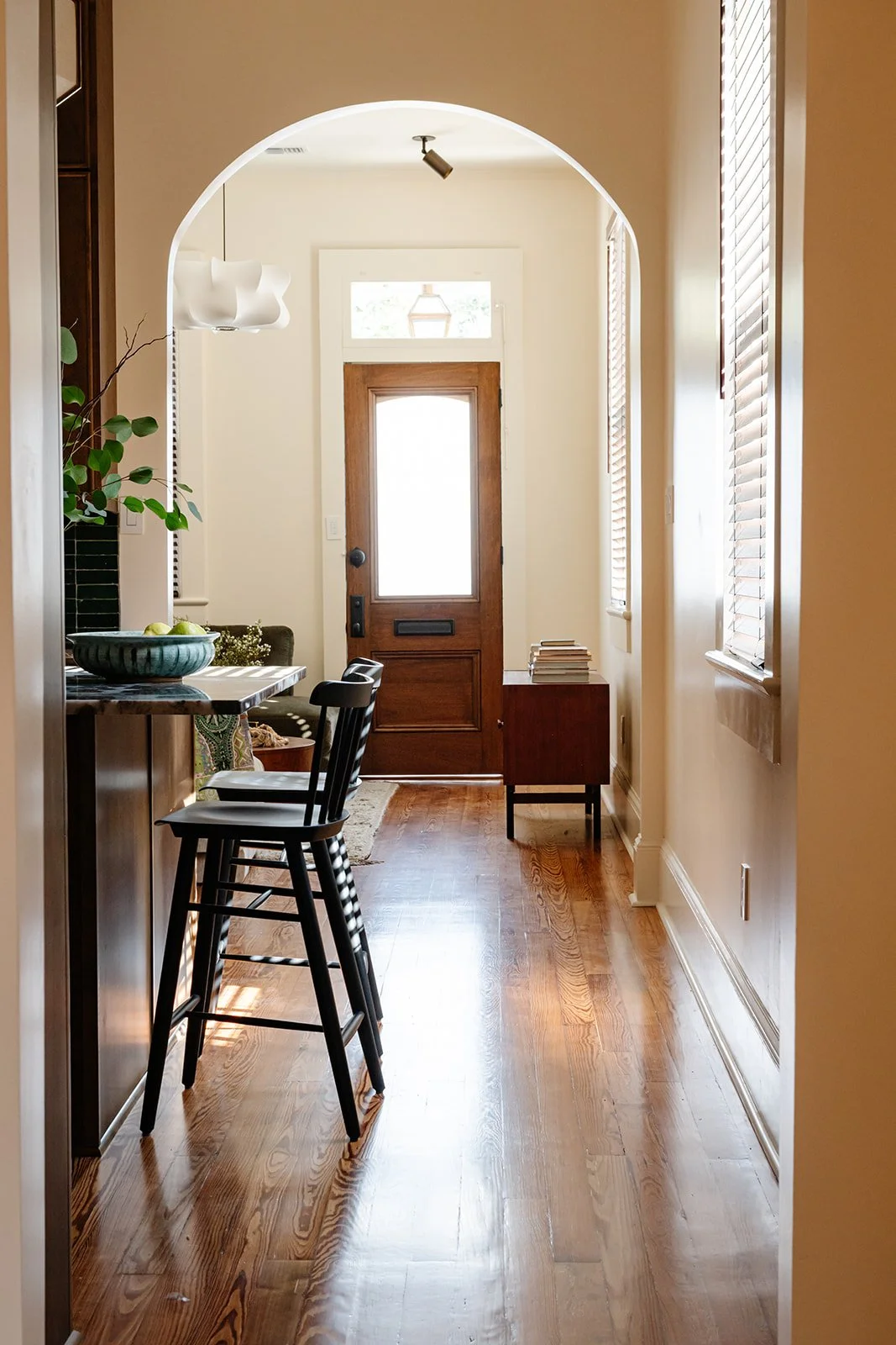 Entry view: View through arched doorways to the original front door of a renovated double shotgun