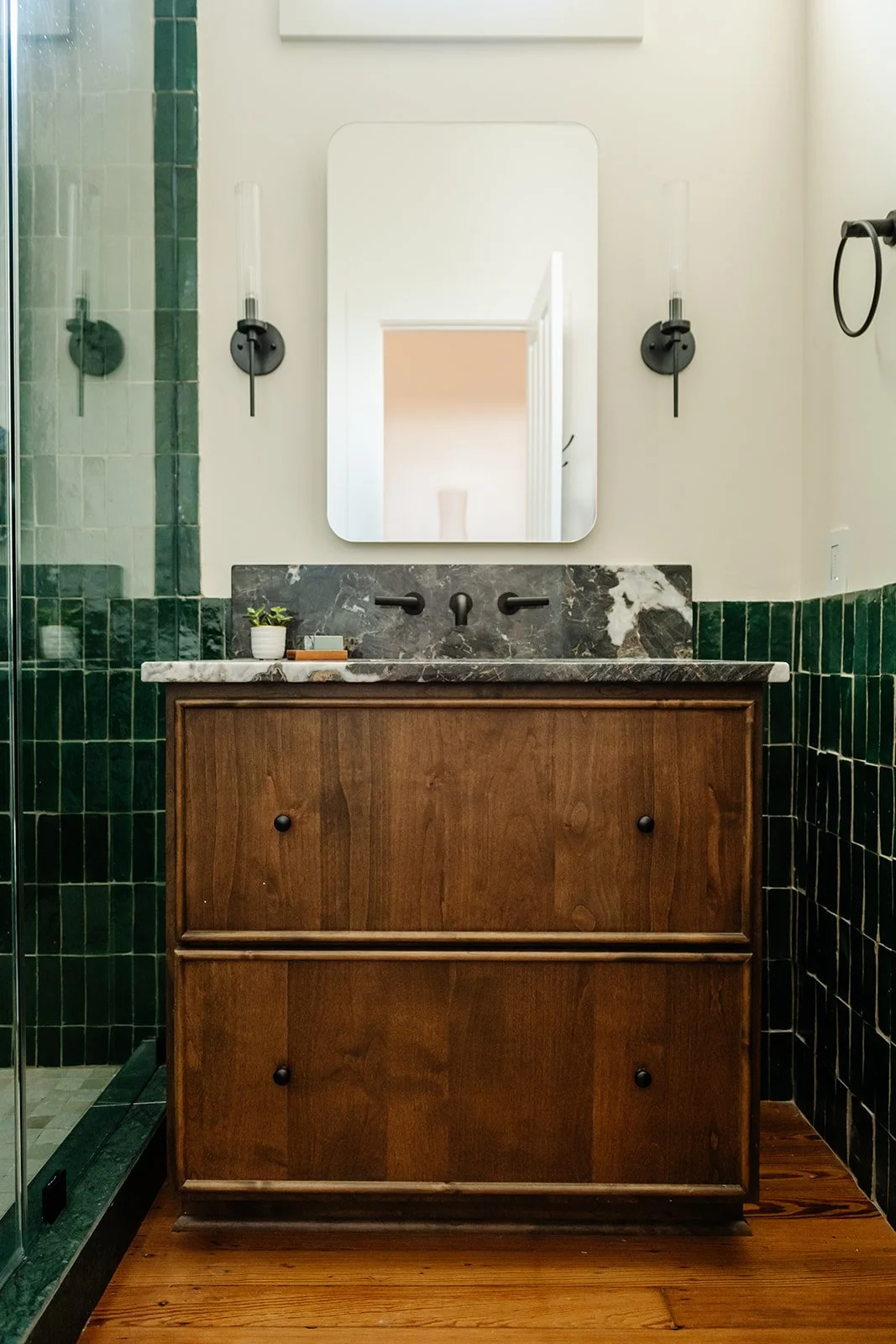 Green tile bath: Primary bathroom with green zellige tile and custom walnut vanity