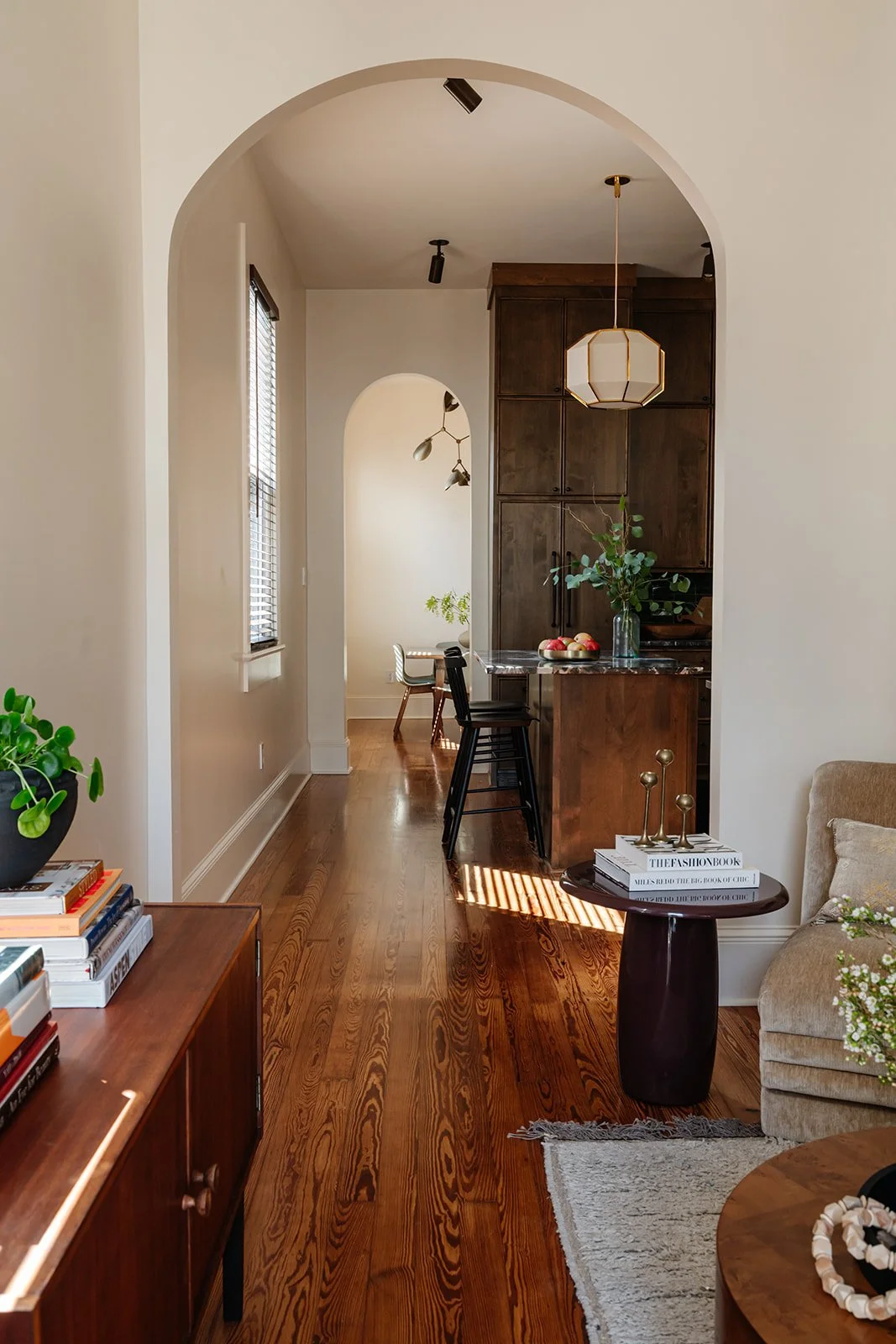 Hallway view: Open sightline through a renovated shotgun home from living room to kitchen
