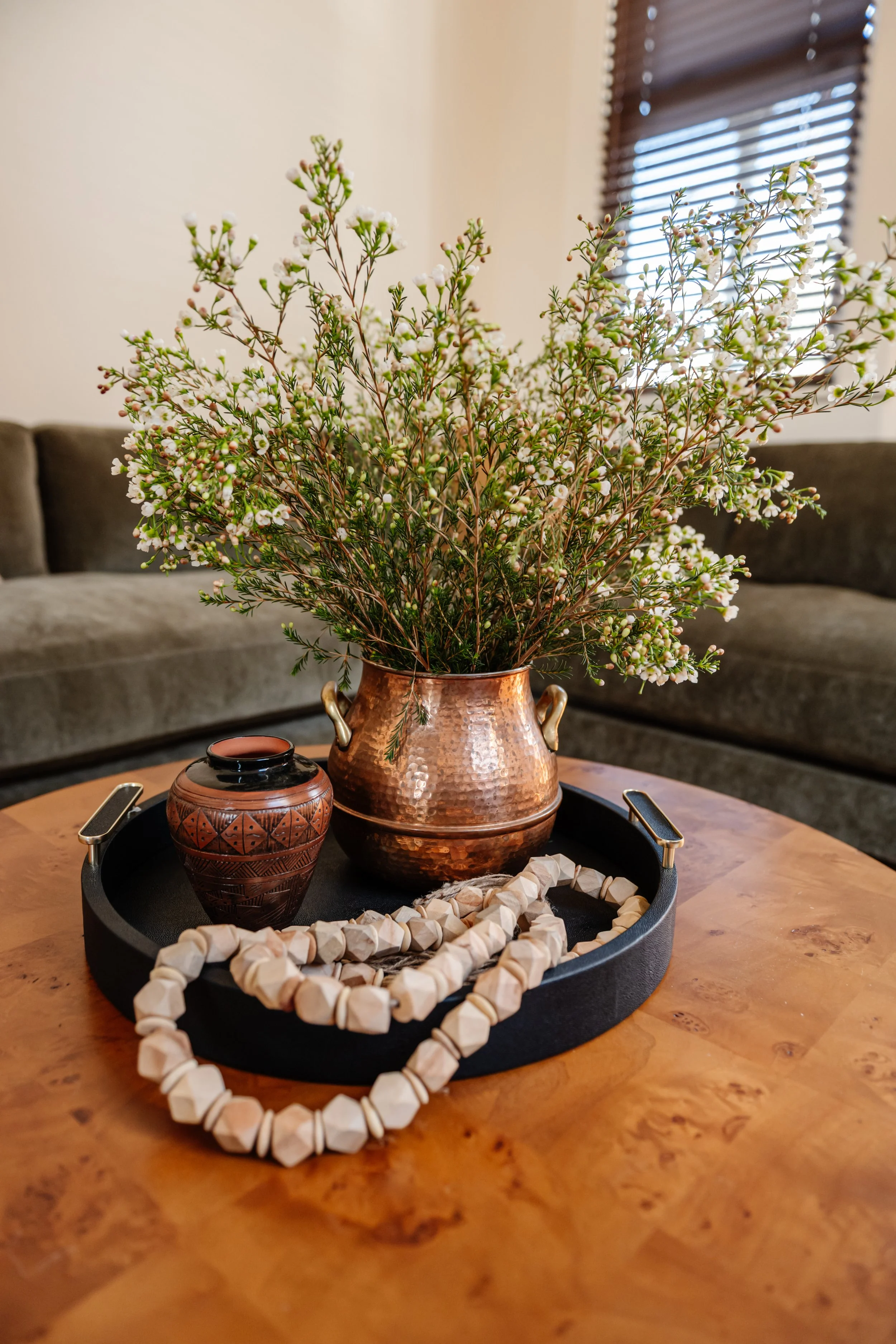 Coffee table detail: Burl wood coffee table styled with copper vase and vintage accessories