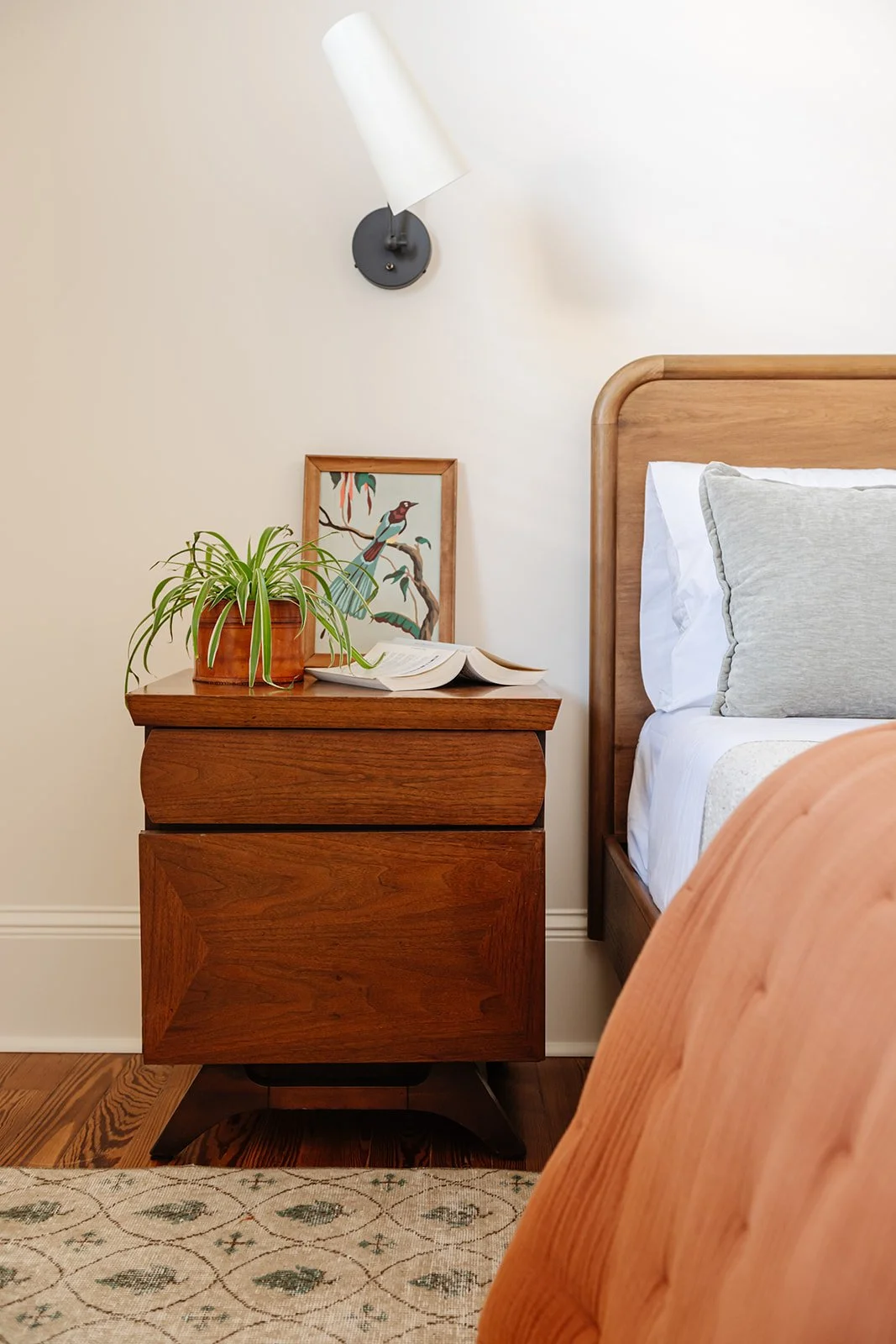 Bedroom vignettes: Primary bedroom with vintage nightstand and wall sconce in a gut renovated New Orleans home