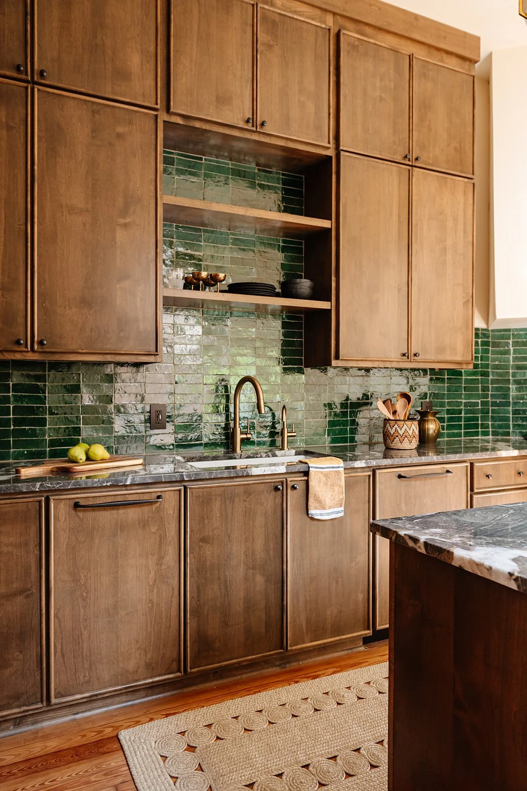 Kitchen run: Full kitchen wall with green tile backsplash and floor-to-ceiling cabinetry in a shotgun house renovation