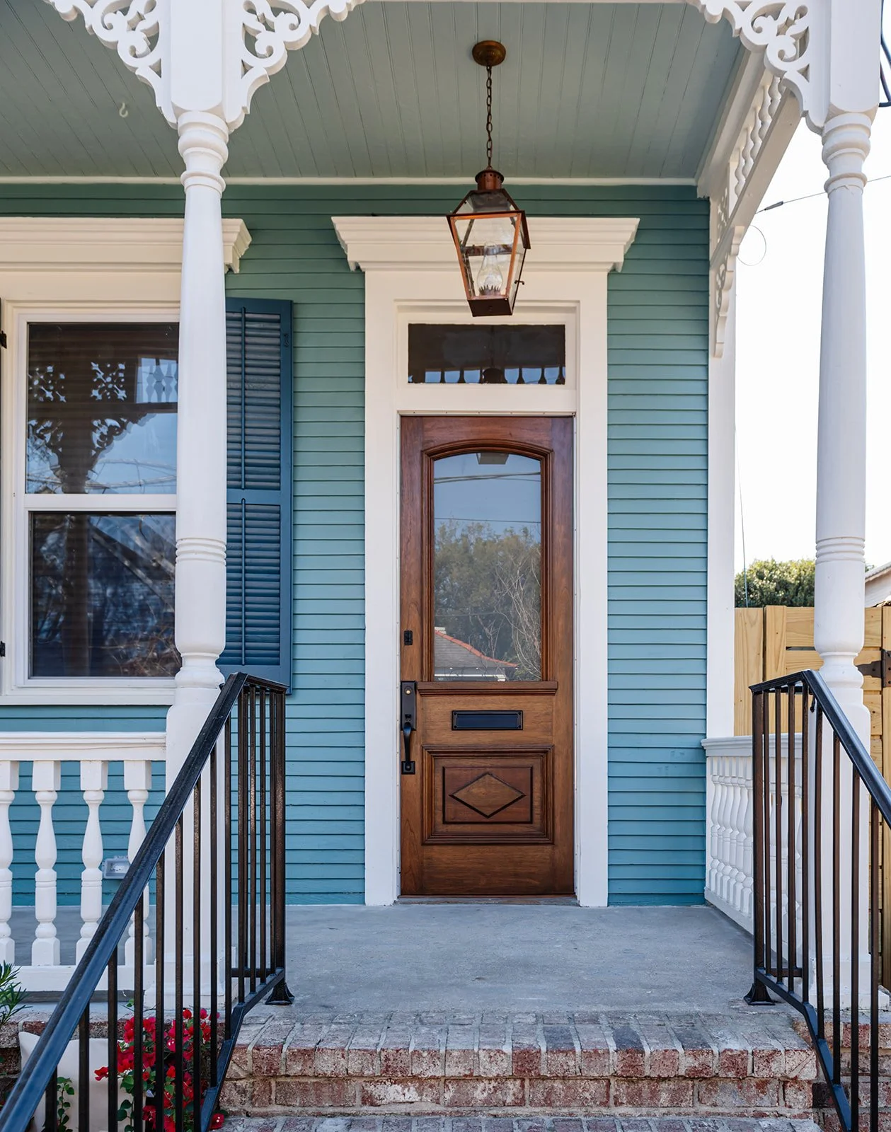 Porch: Historic front porch with gas lantern and original wood door on a renovated Carrollton shotgun