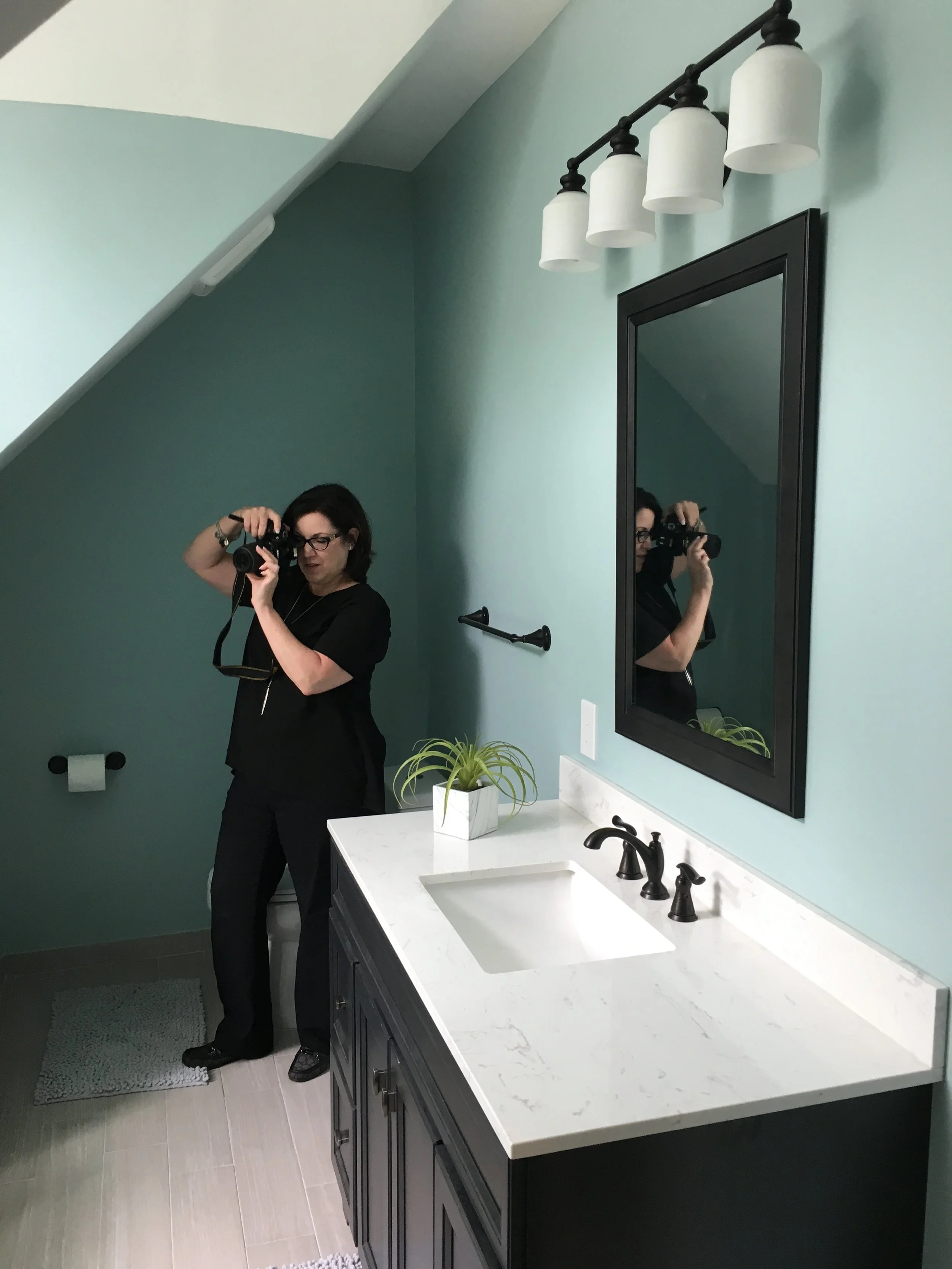 We used black in this bathroom to add a little edge to the light, soothing space. Christine is hard at work photographing our design.