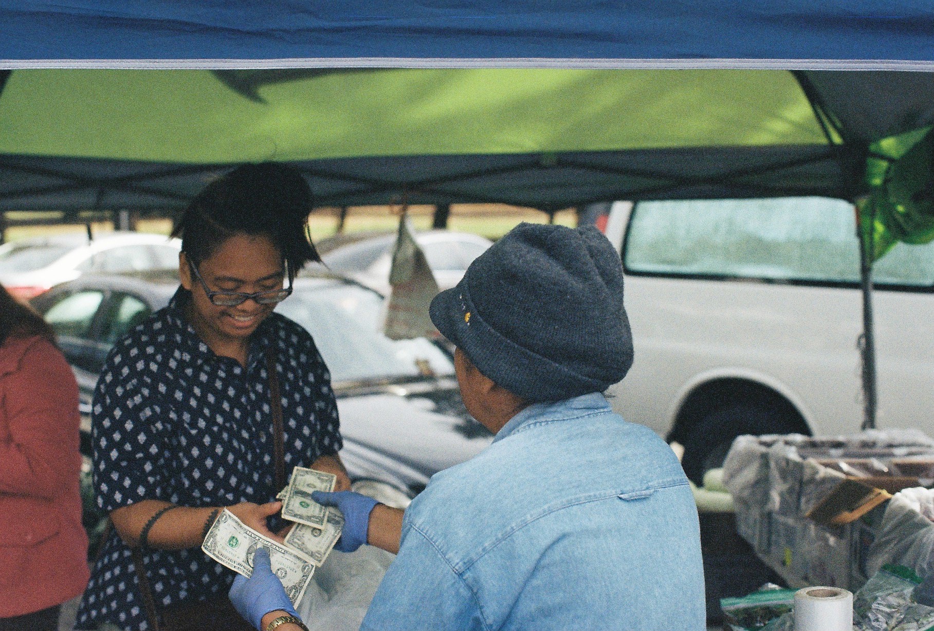 The author smiling during a conversation with Auntie L. while exchanging money for vegetables / Photo by Thanh Hằng Phạm 
