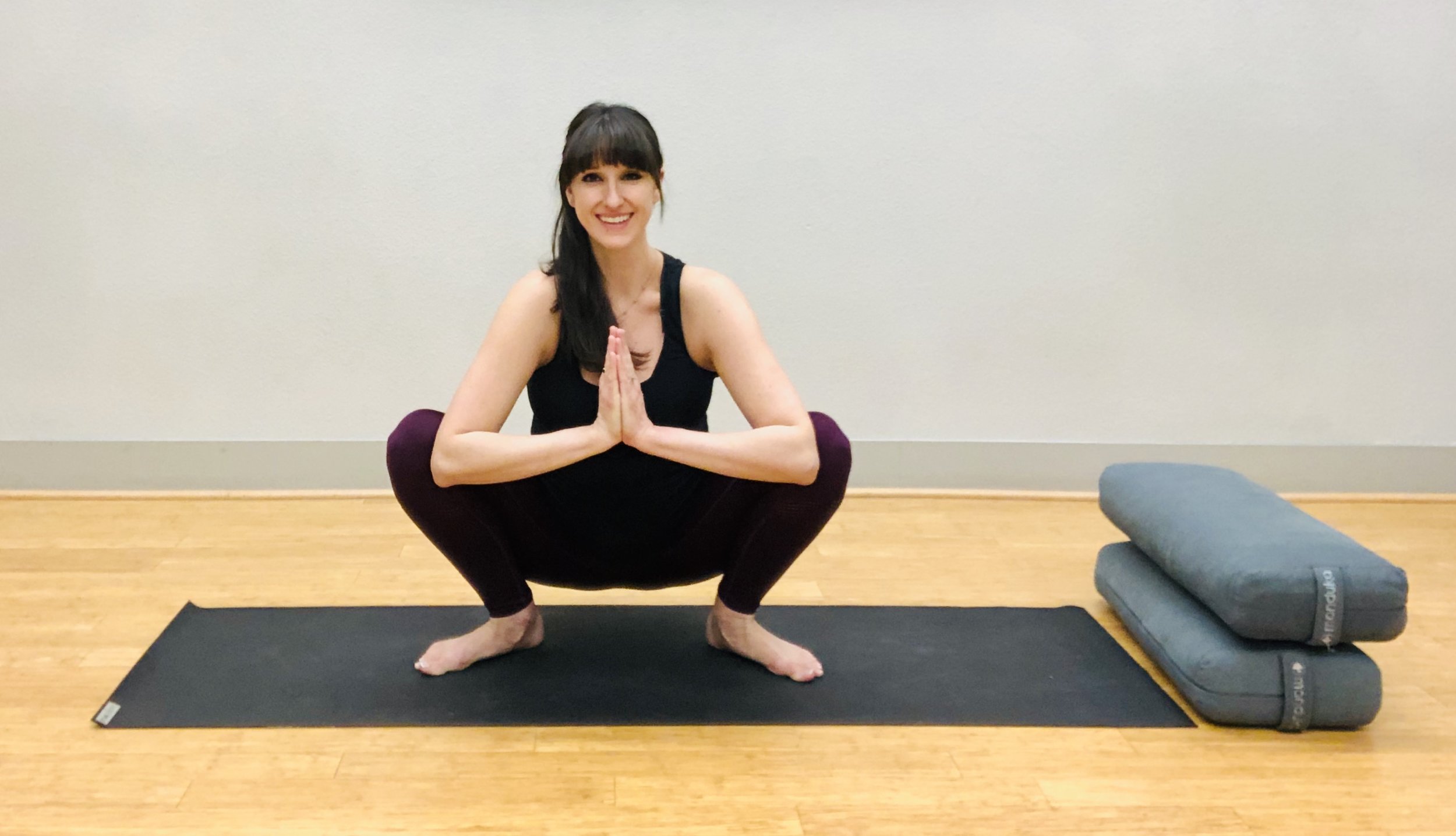 Squat again to come to floor. Other options include sitting on a ball, bolster or pillow. Heels may be lifted, but aim to keep feet wide and flat on the floor. See video for partner-assisted variations!