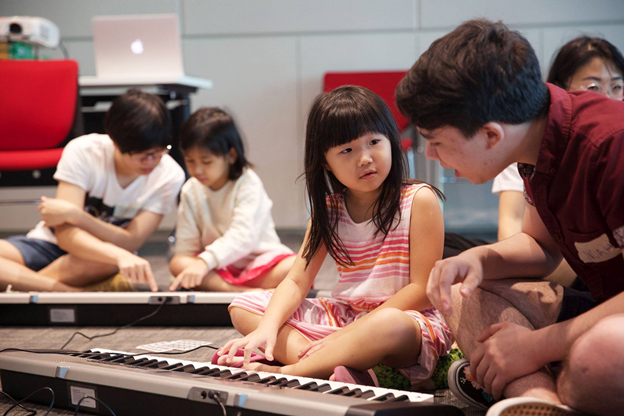 Above: YST composition student Noah Diggs (far right) guides a keen learner from the Superhero Me program.