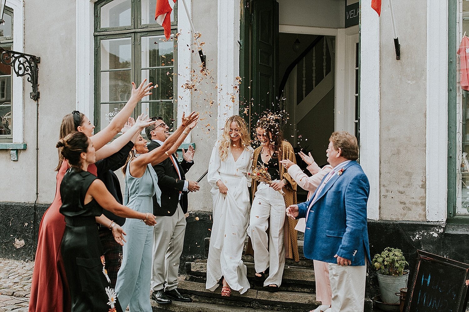 Wedding guests tossing flower petals | Gay couple getting married in Denmark | lgbtq+ weddings | Denmark wedding venue | Aero Island | Danish Island Weddings | Full service wedding planners