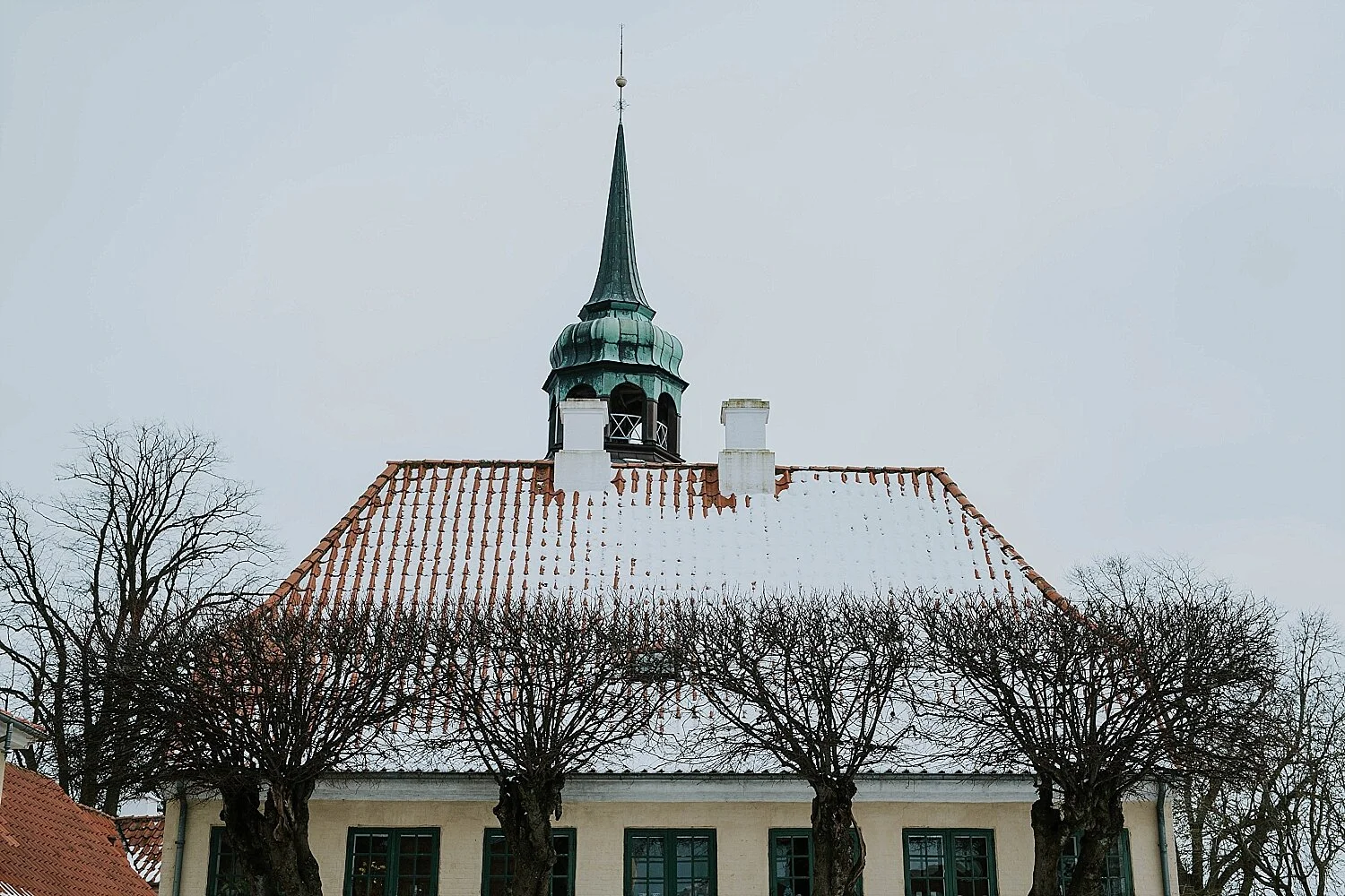 An authentic winter scene of the historic Visdomskilden building at the town square in Aeroskobing, showcasing the quiet season setting for an elopement on Aeroe.