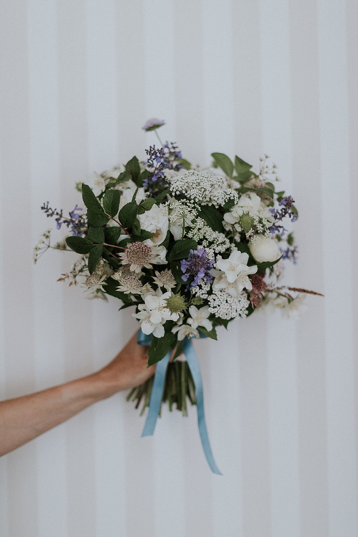 hand-tied wedding bouquet in front of pink and white striped wall | Denmark wedding planners and florist