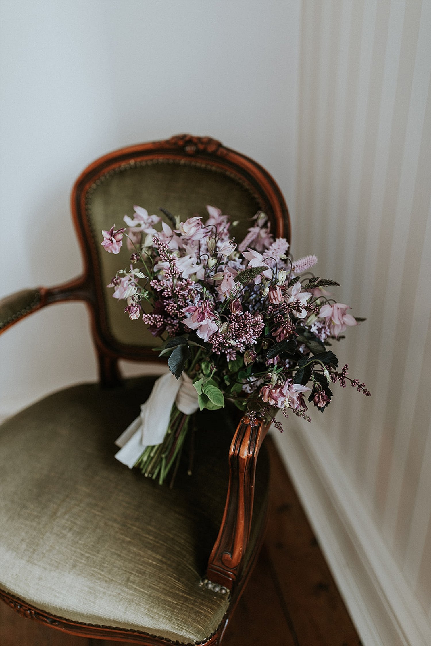 pink and purple flower bouquet on vintage chair | Aero Island wedding planners | Denmark weddings and florists